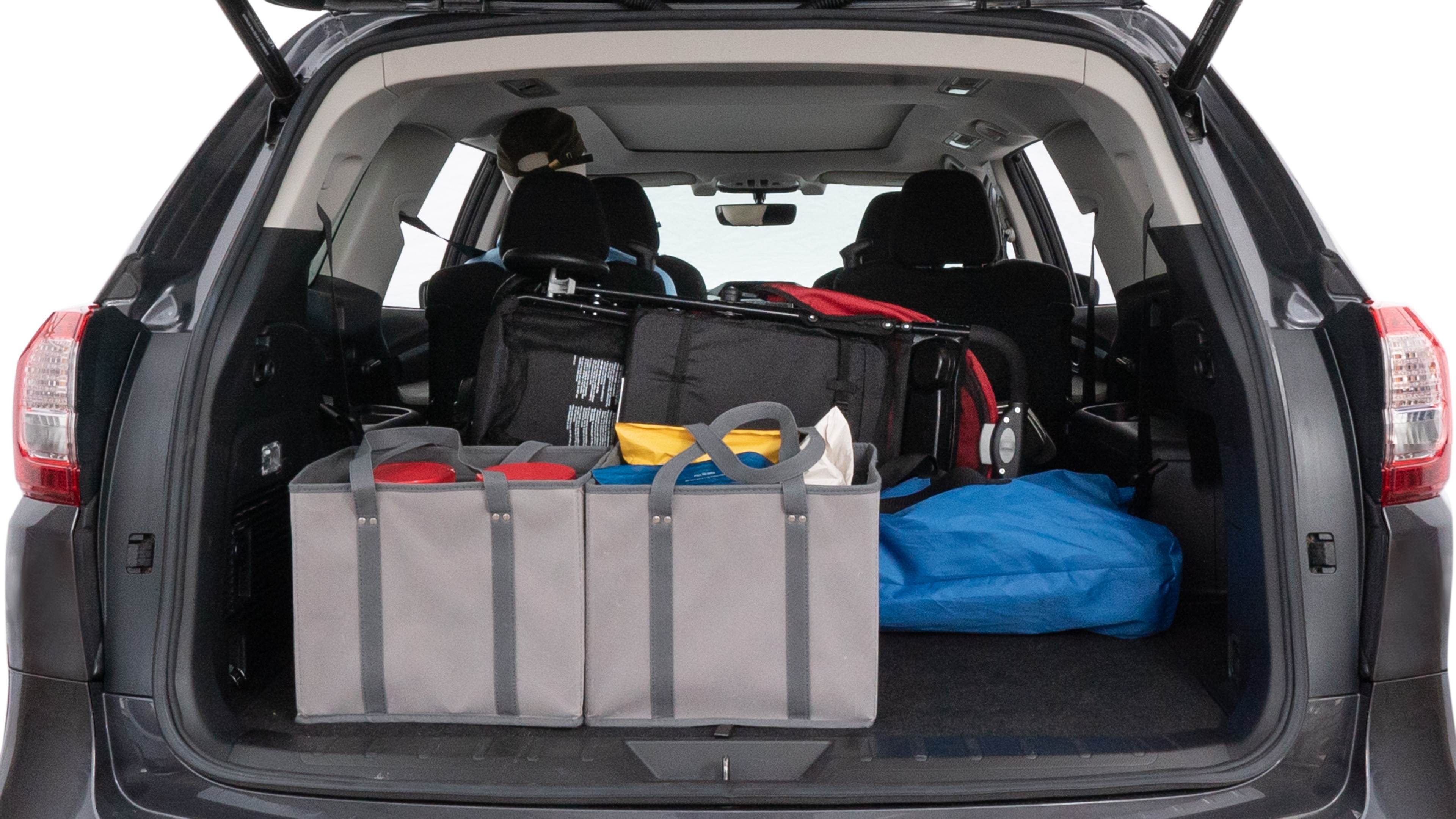 The trunk lid is open showing full view of the trunk. A baby stroller, three grocery carriers, two camping chairs in the carrying bag, and a set of golf clubs are placed inside.
