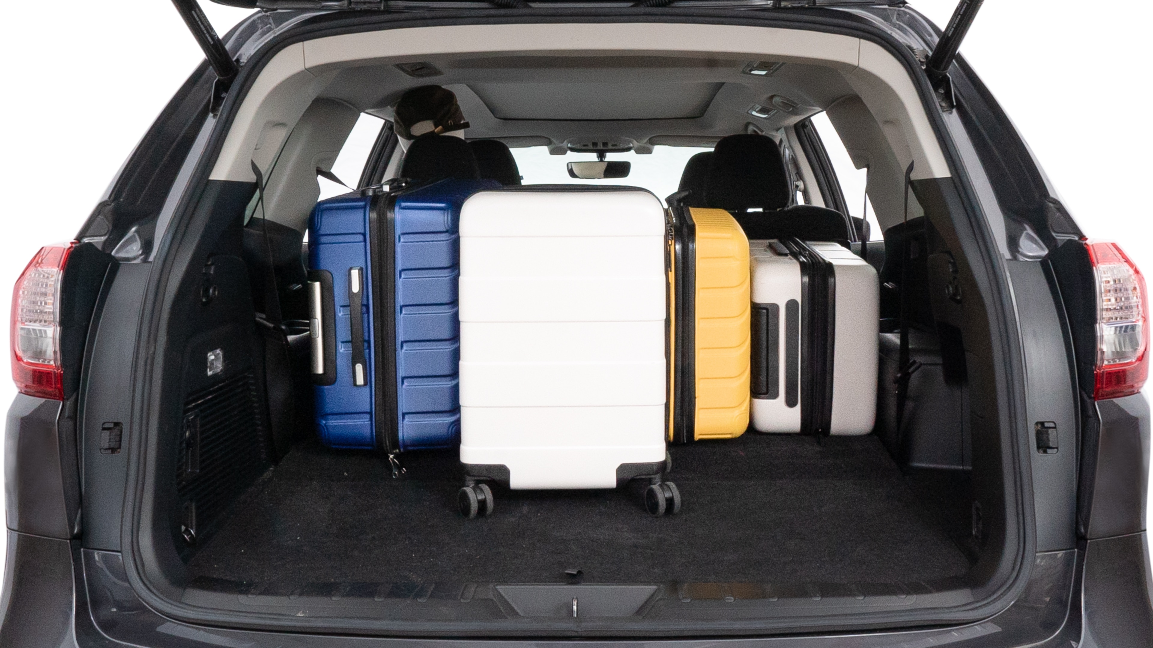 The trunk lid is open, showing full view of the trunk space. One large, two medium, and two small suitcases are placed inside.