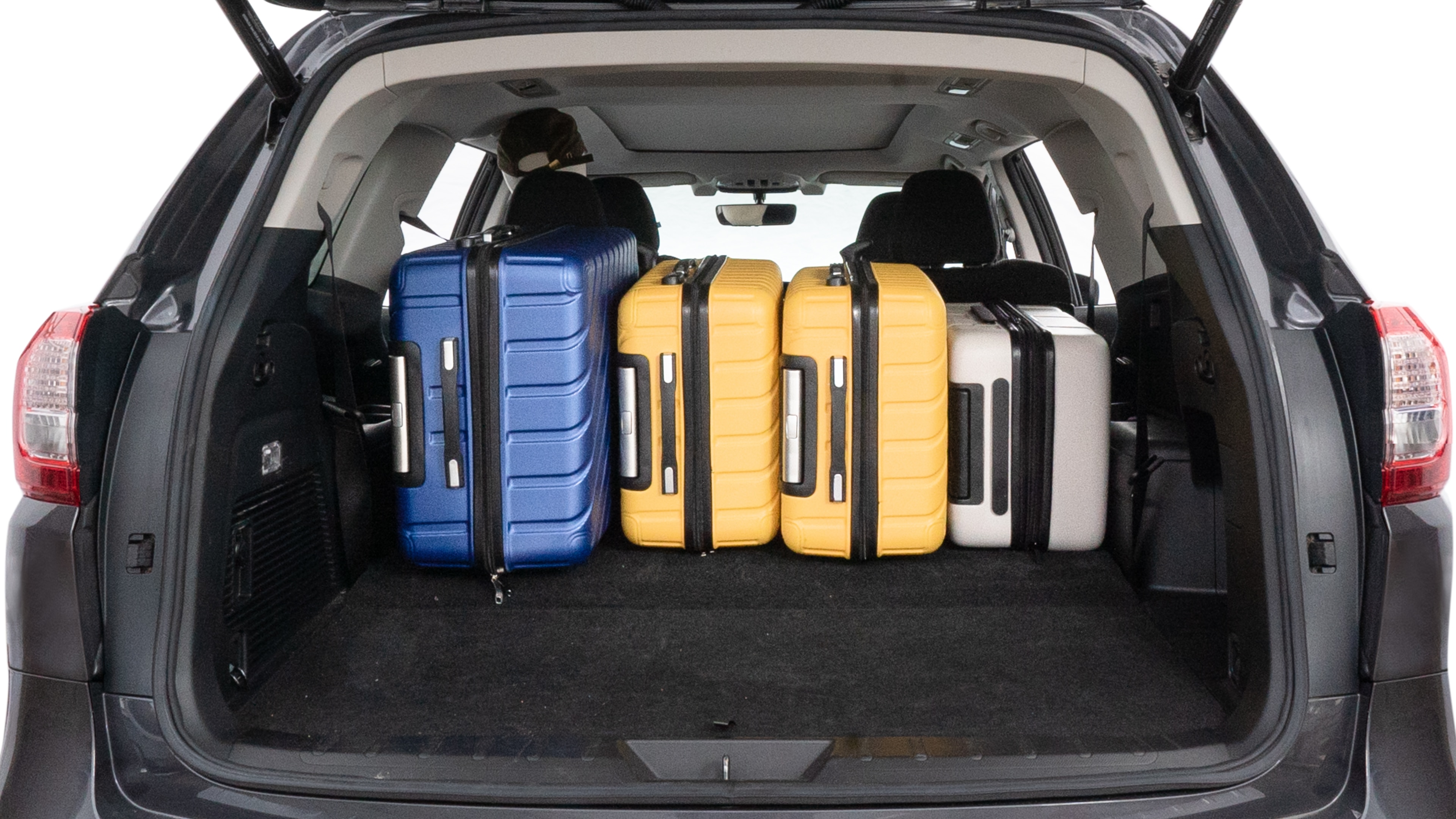 The trunk lid is open, showing full view of the trunk space. One large, two medium, and two small suitcases are placed inside.