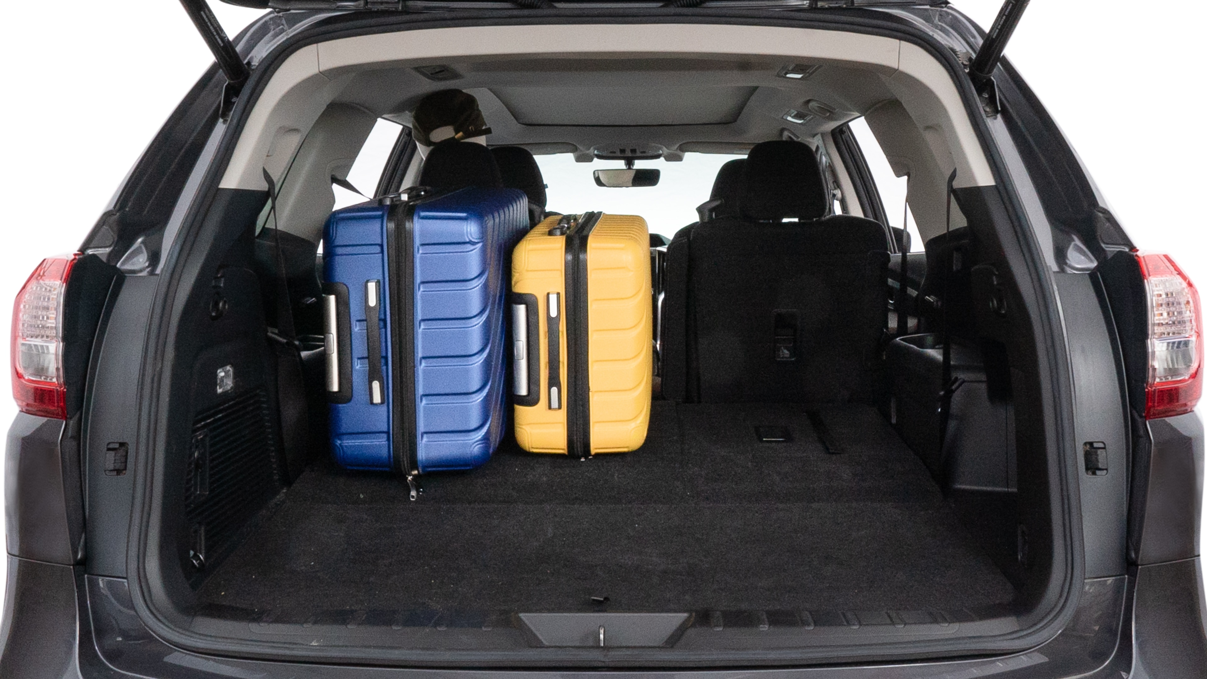 The trunk lid is open, showing full view of the trunk space. One large, two medium, and two small suitcases are placed inside.