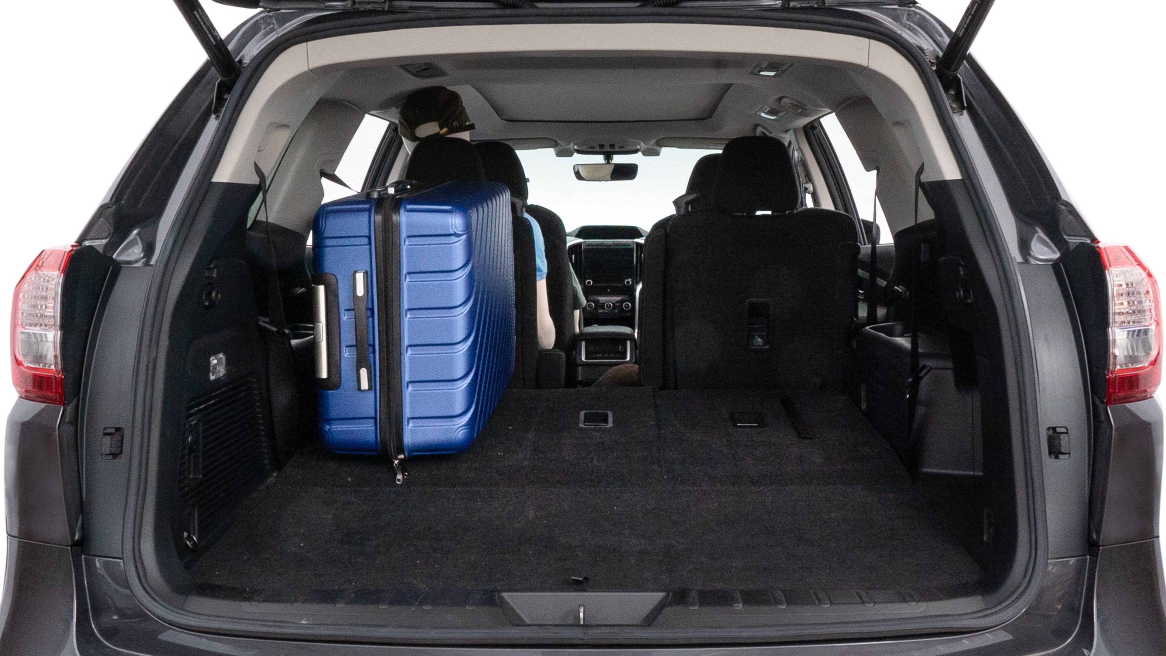 The trunk lid is open, showing full view of the trunk space. One large, two medium, and two small suitcases are placed inside.