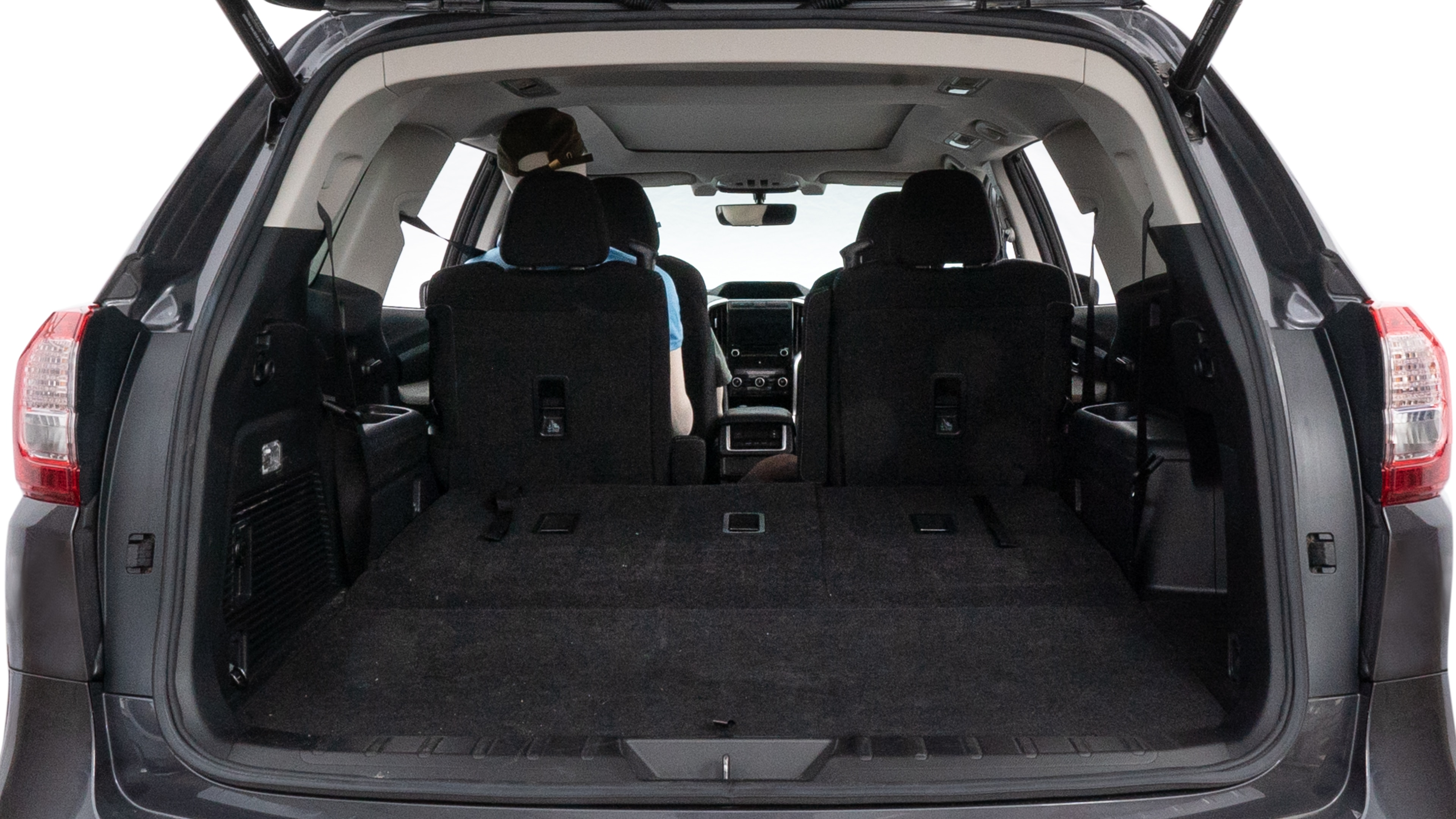 The trunk lid is open, showing full view of the trunk space. One large, two medium, and two small suitcases are placed inside.