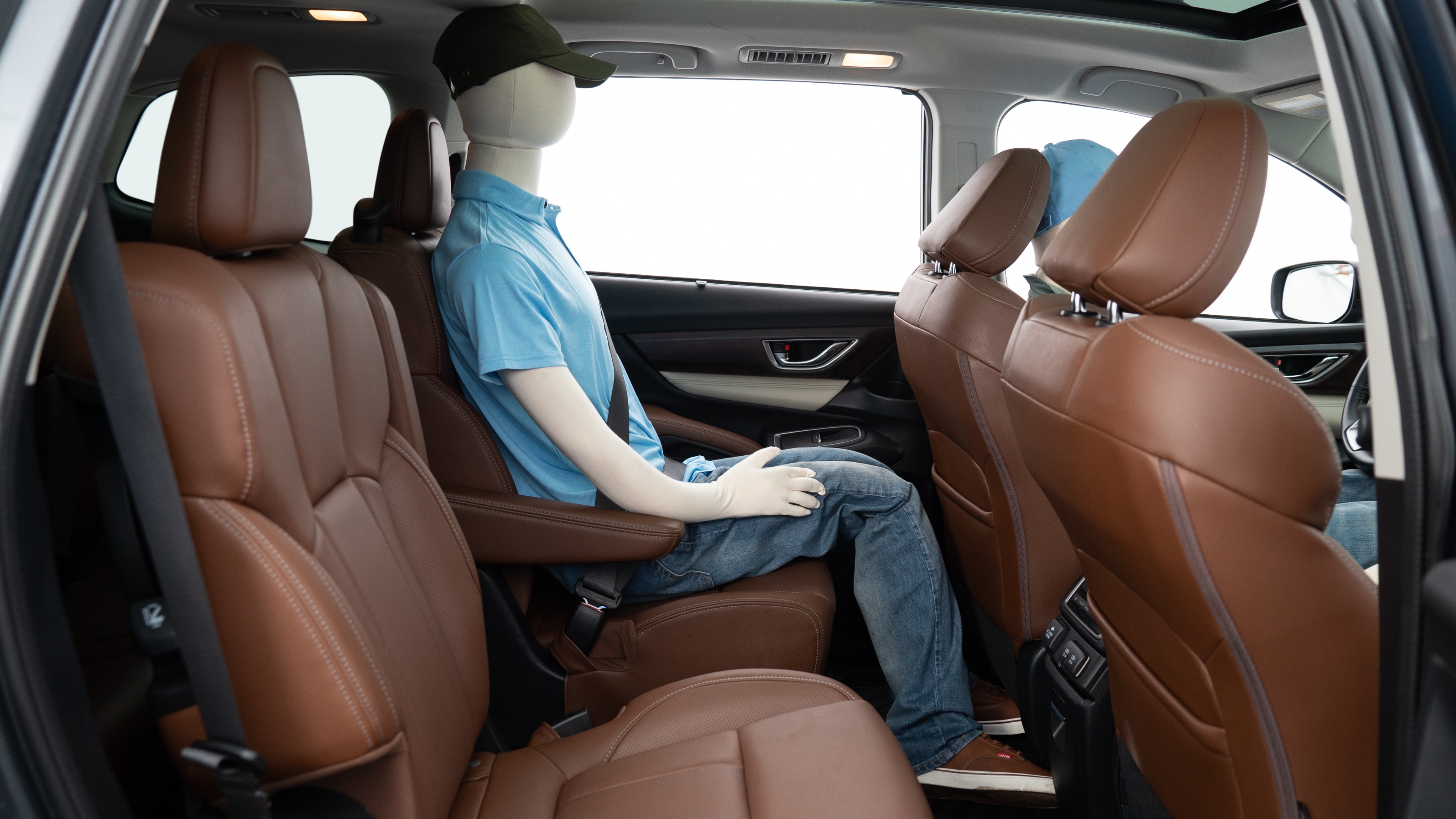 A series of second-row backseat photos is shown including one seating a baby seat, a dog and one seating a 6'1" mannequin.