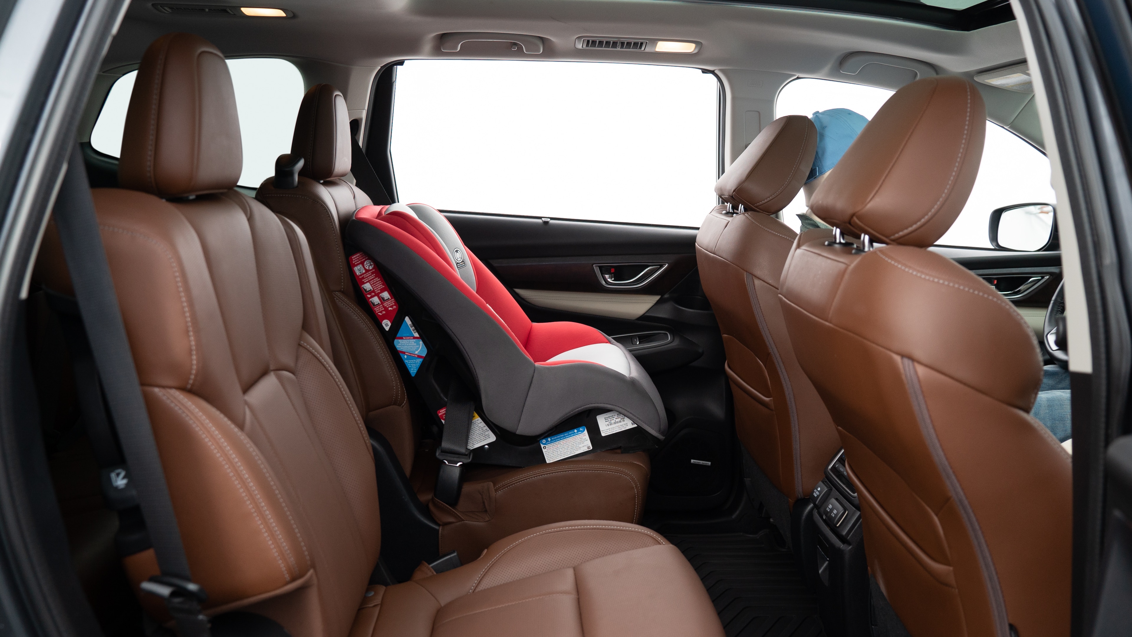 A series of second-row backseat photos is shown including one seating a baby seat, a dog and one seating a 6'1" mannequin.