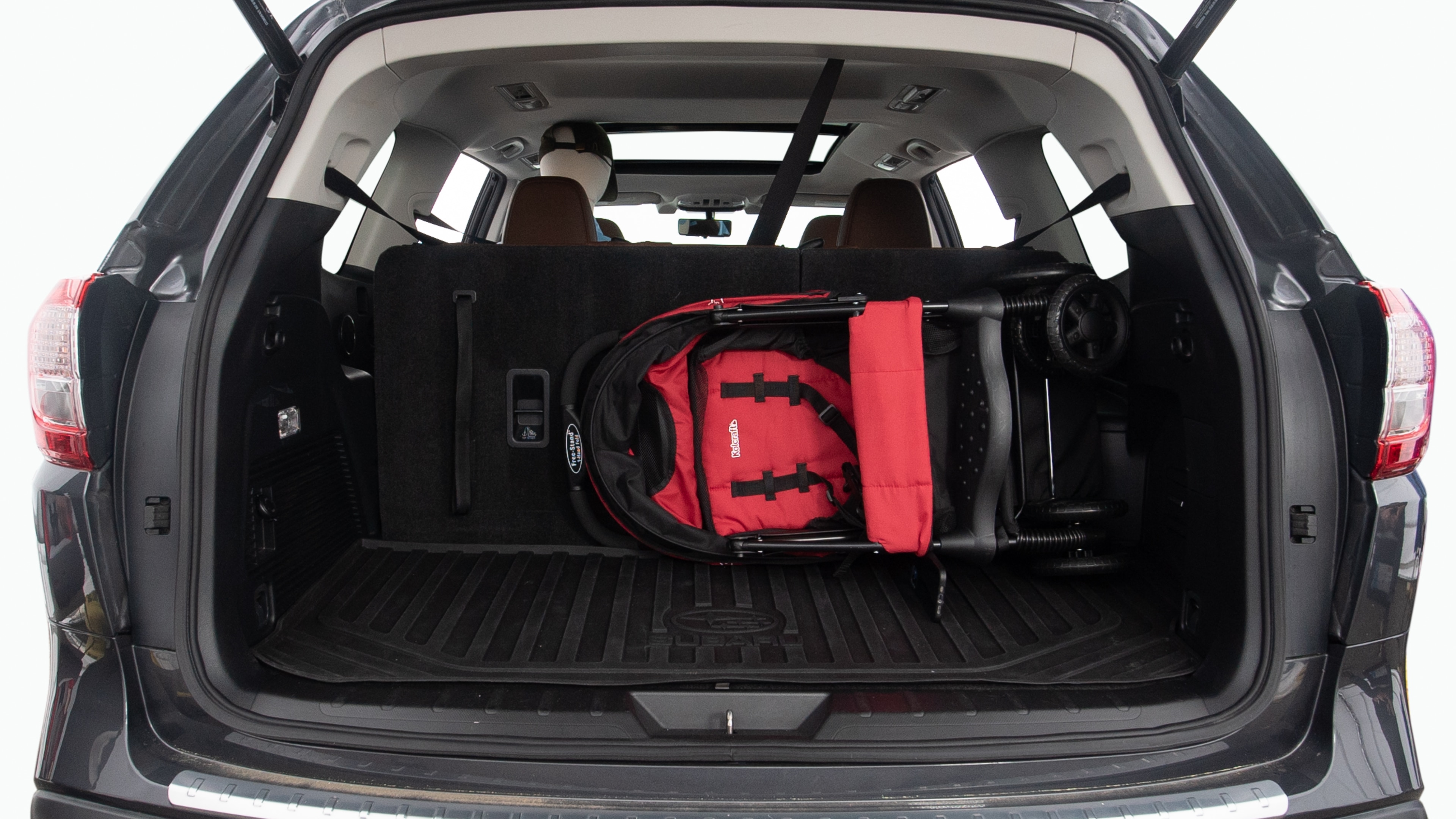 The trunk lid is open showing full view of the trunk. Two grocery carriers, two camping chairs in the carrying bag, and a set of golf clubs are placed inside.