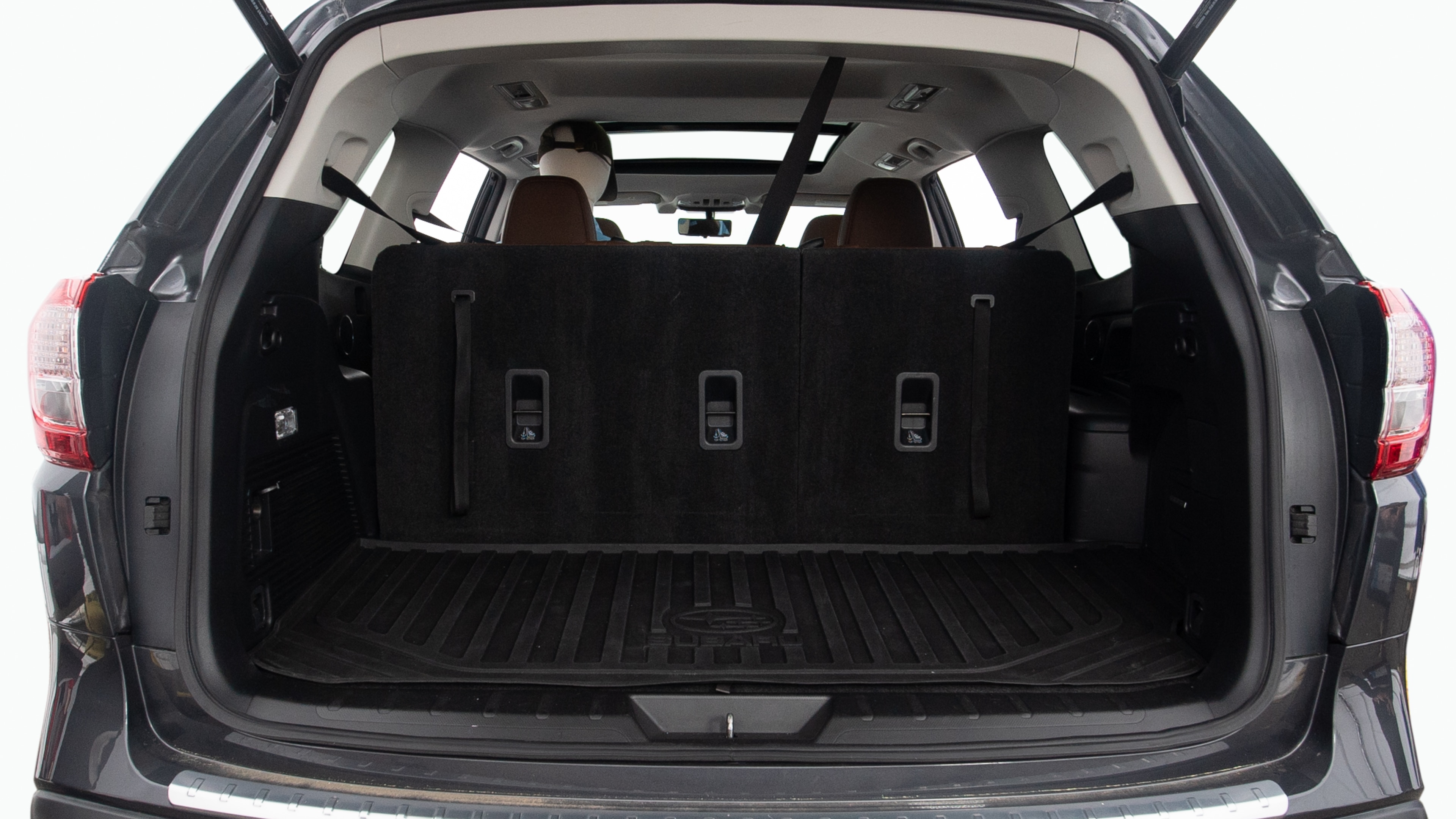 The trunk lid is open, showing full view of the trunk space. Two large and two small suitcases are placed inside.