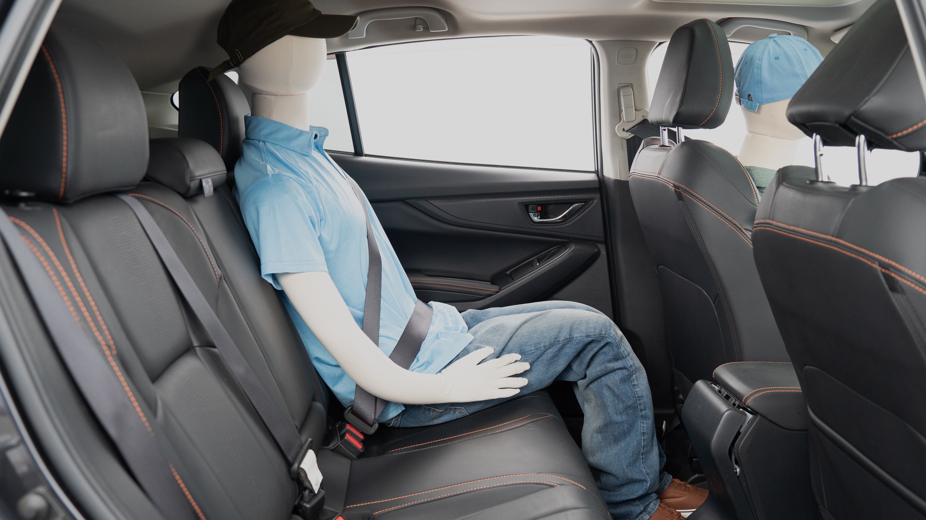 A series of second-row backseat photos is shown including one seating a baby seat, a dog and one seating a 6'1" mannequin.