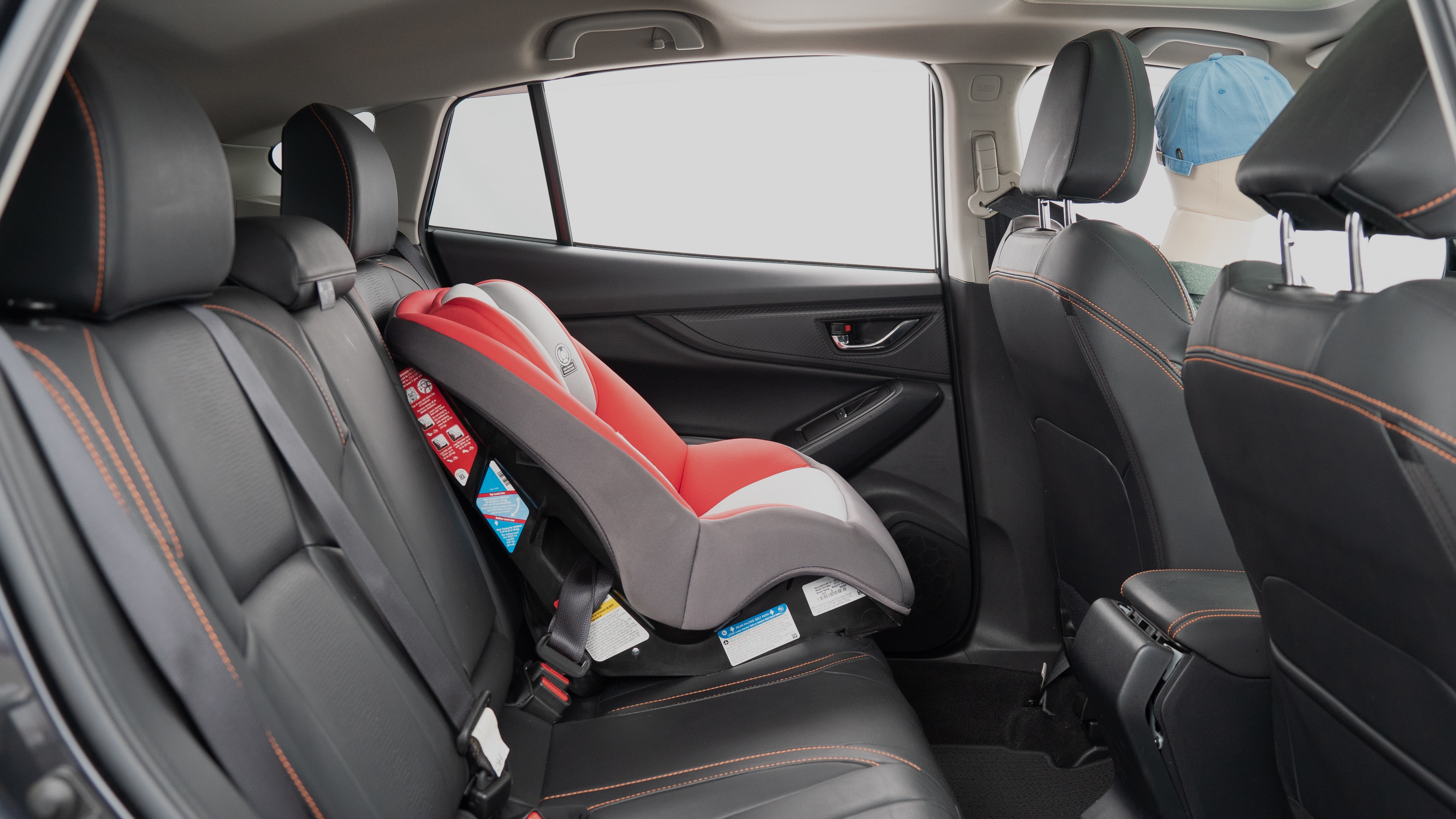 A series of second-row backseat photos is shown including one seating a baby seat, a dog and one seating a 6'1" mannequin.
