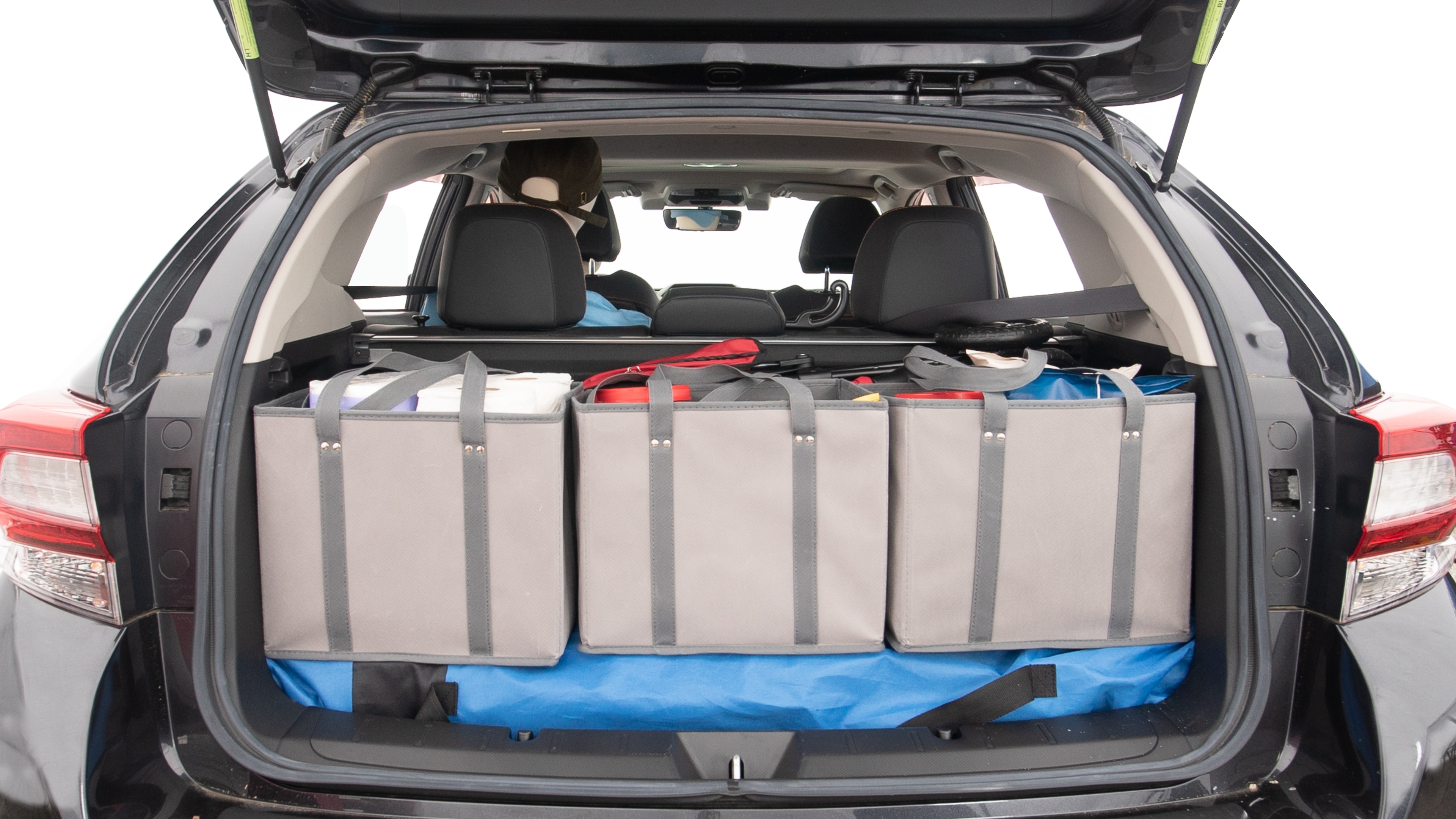 The trunk lid is open showing full view of the trunk. A baby stroller, three grocery carriers, two camping chairs in the carrying bag, and a set of golf clubs are placed inside.