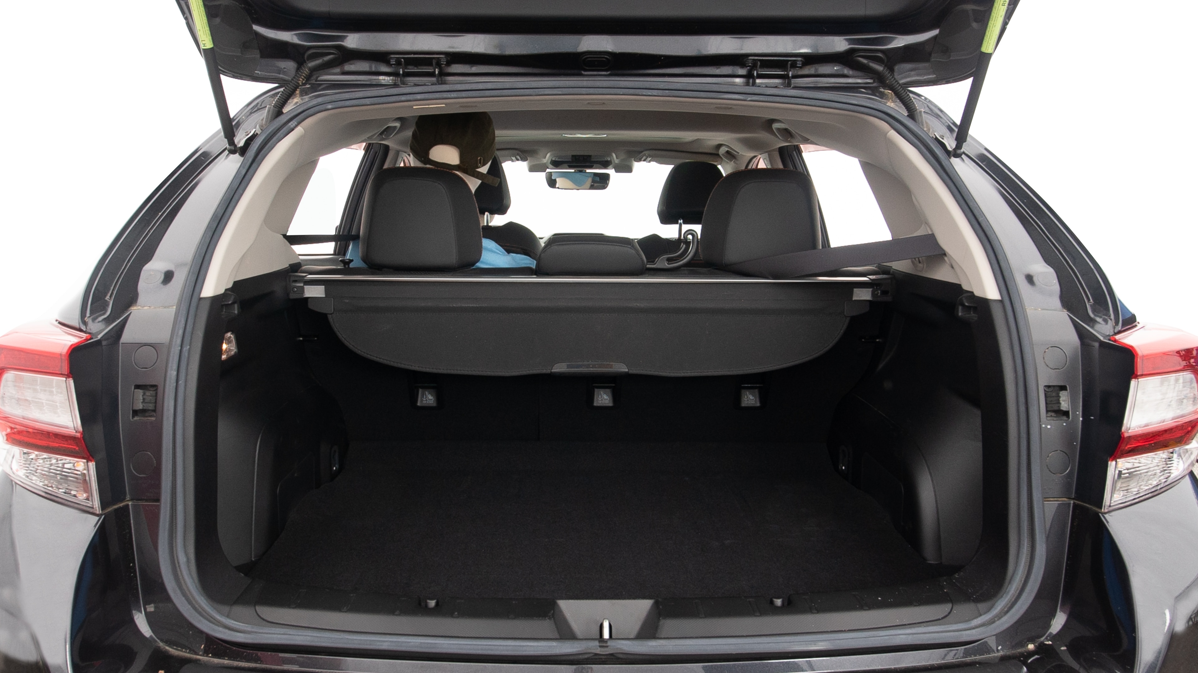 The trunk lid is open showing full view of the trunk. A baby stroller, three grocery carriers, two camping chairs in the carrying bag, and a set of golf clubs are placed inside.