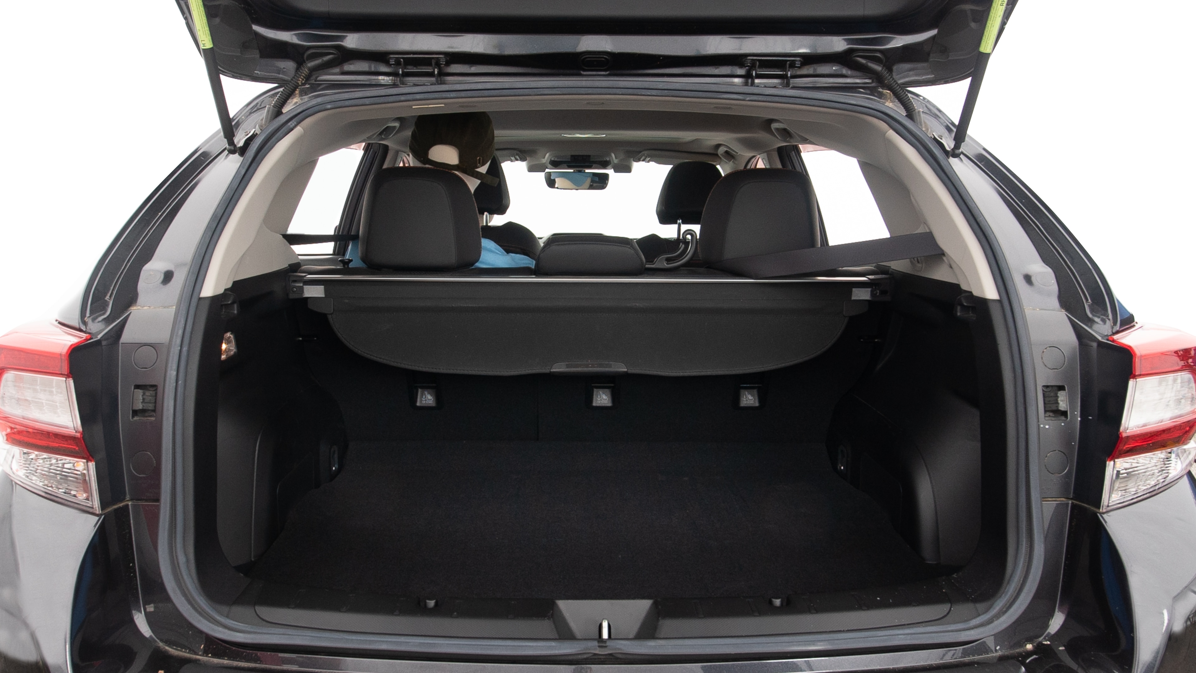 The trunk lid is open, showing full view of the trunk space. Two large and one small suitcases are placed inside.