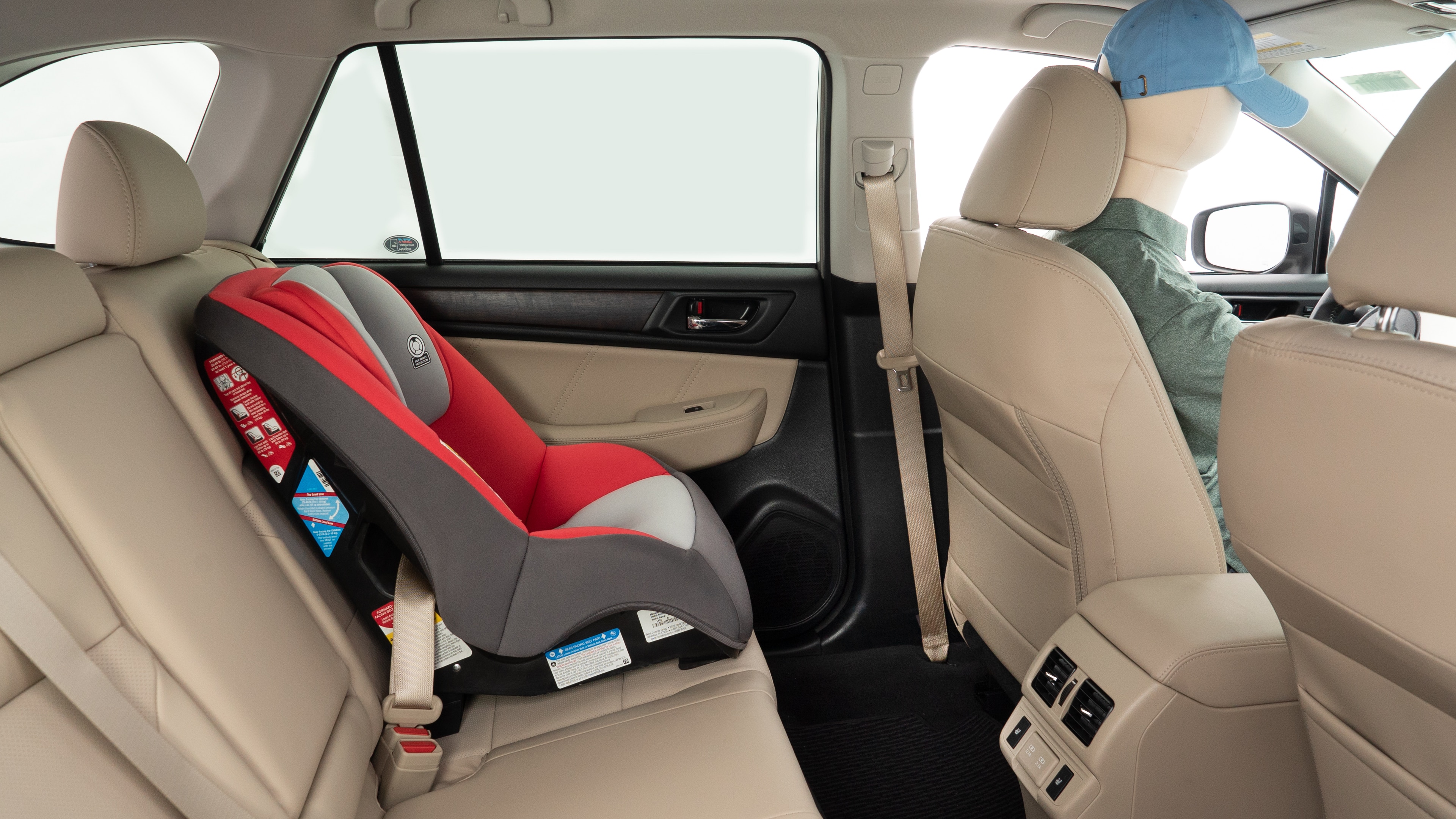 A series of second-row backseat photos is shown including one seating a baby seat and one seating a 6'1" mannequin.