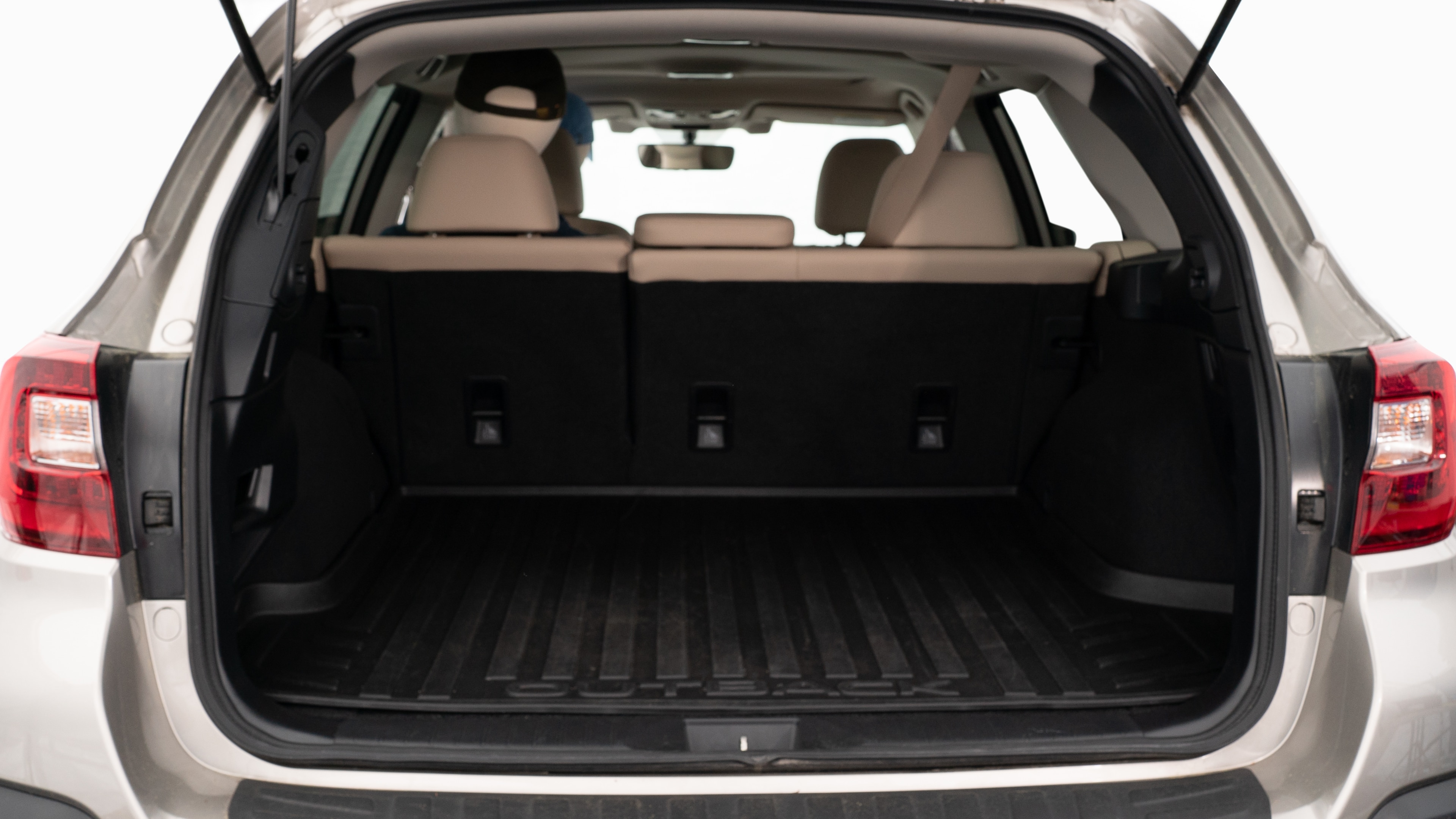 The trunk lid is open showing full view of the trunk. A baby stroller, three grocery carriers, two camping chairs in the carrying bag, and a set of golf clubs are placed inside.