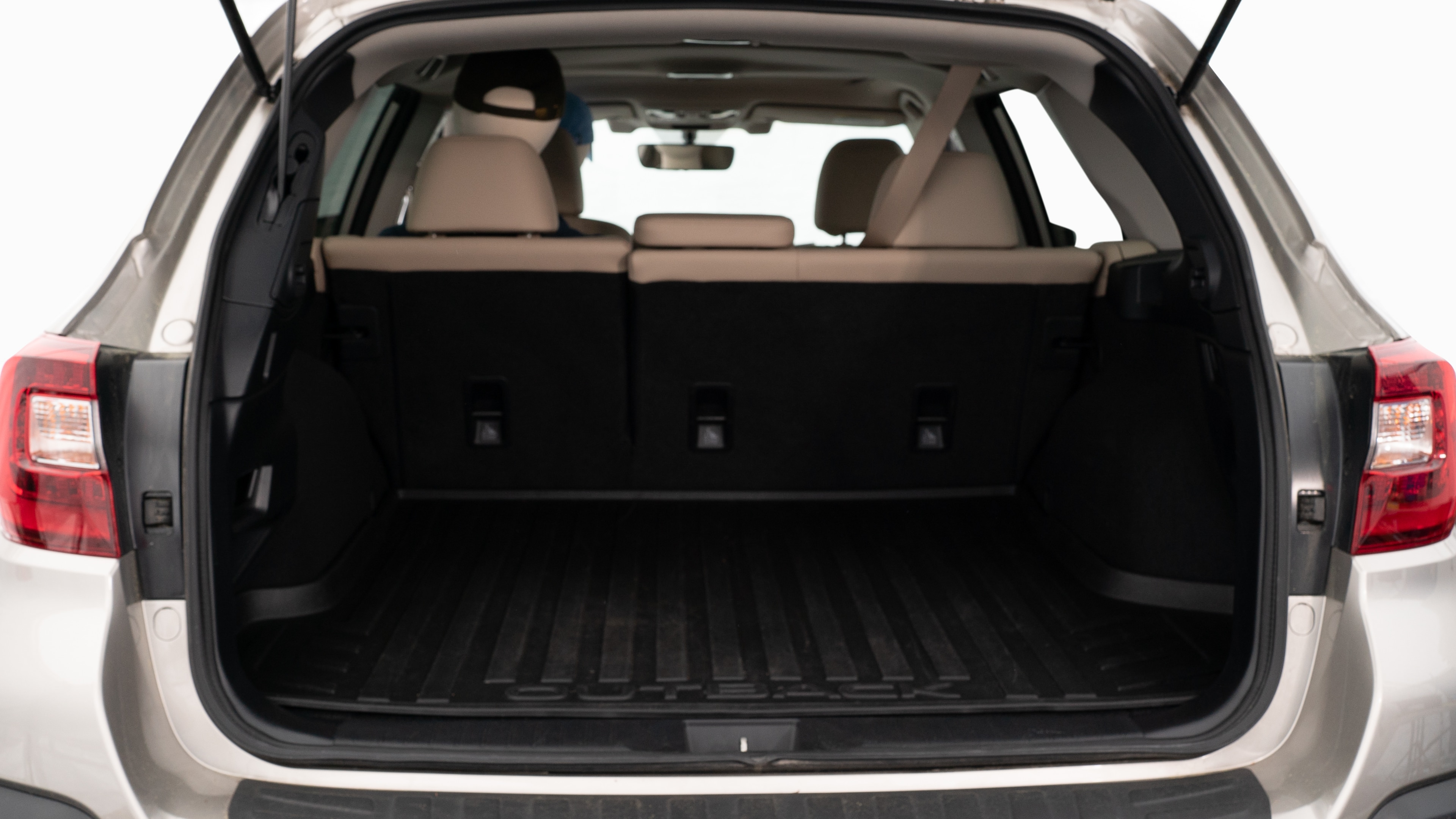 The trunk lid is open, showing a full view of the trunk space. Three large and two small suitcases are placed inside.