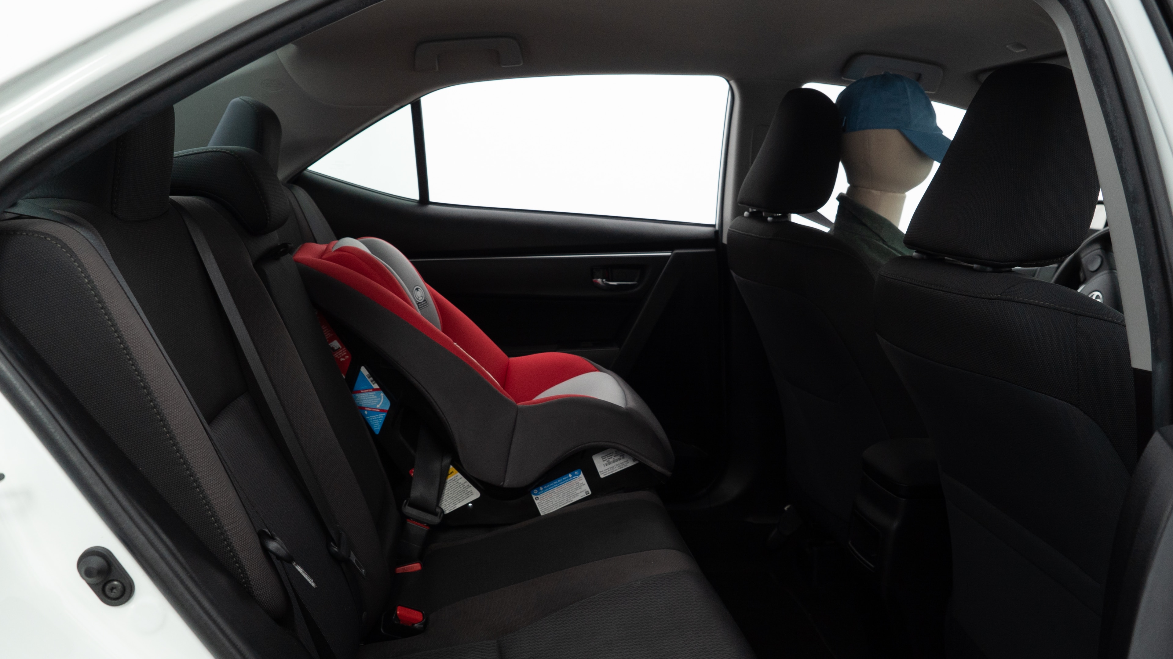 A series of second-row backseat photos is shown including one seating a baby seat and one seating a 6'1" mannequin
