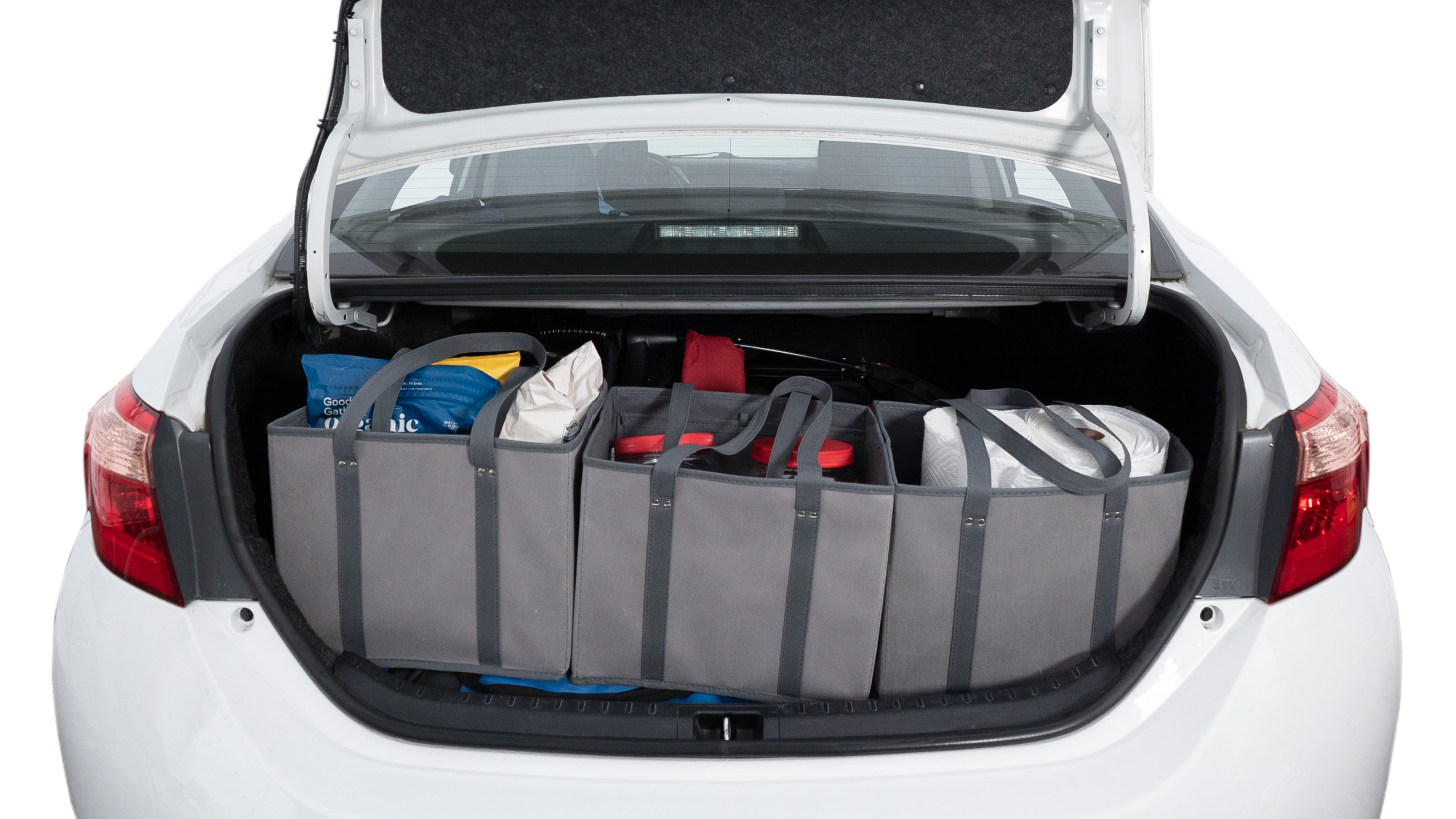 The trunk lid is open showing full view of the trunk. A baby stroller, three grocery carriers, two camping chairs in the carrying bag, and a set of golf clubs are placed inside.