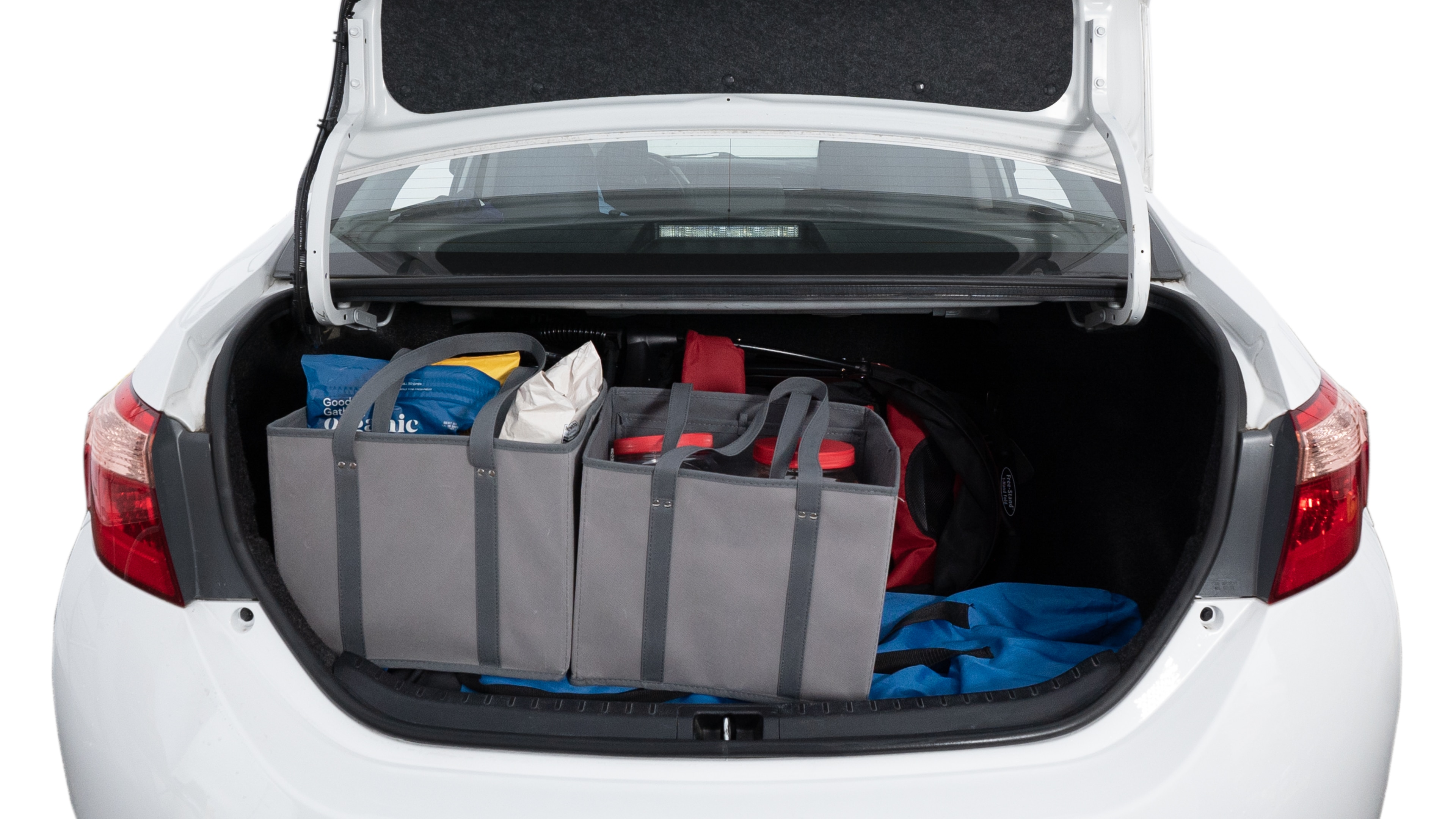 The trunk lid is open showing full view of the trunk. A baby stroller, three grocery carriers, two camping chairs in the carrying bag, and a set of golf clubs are placed inside.