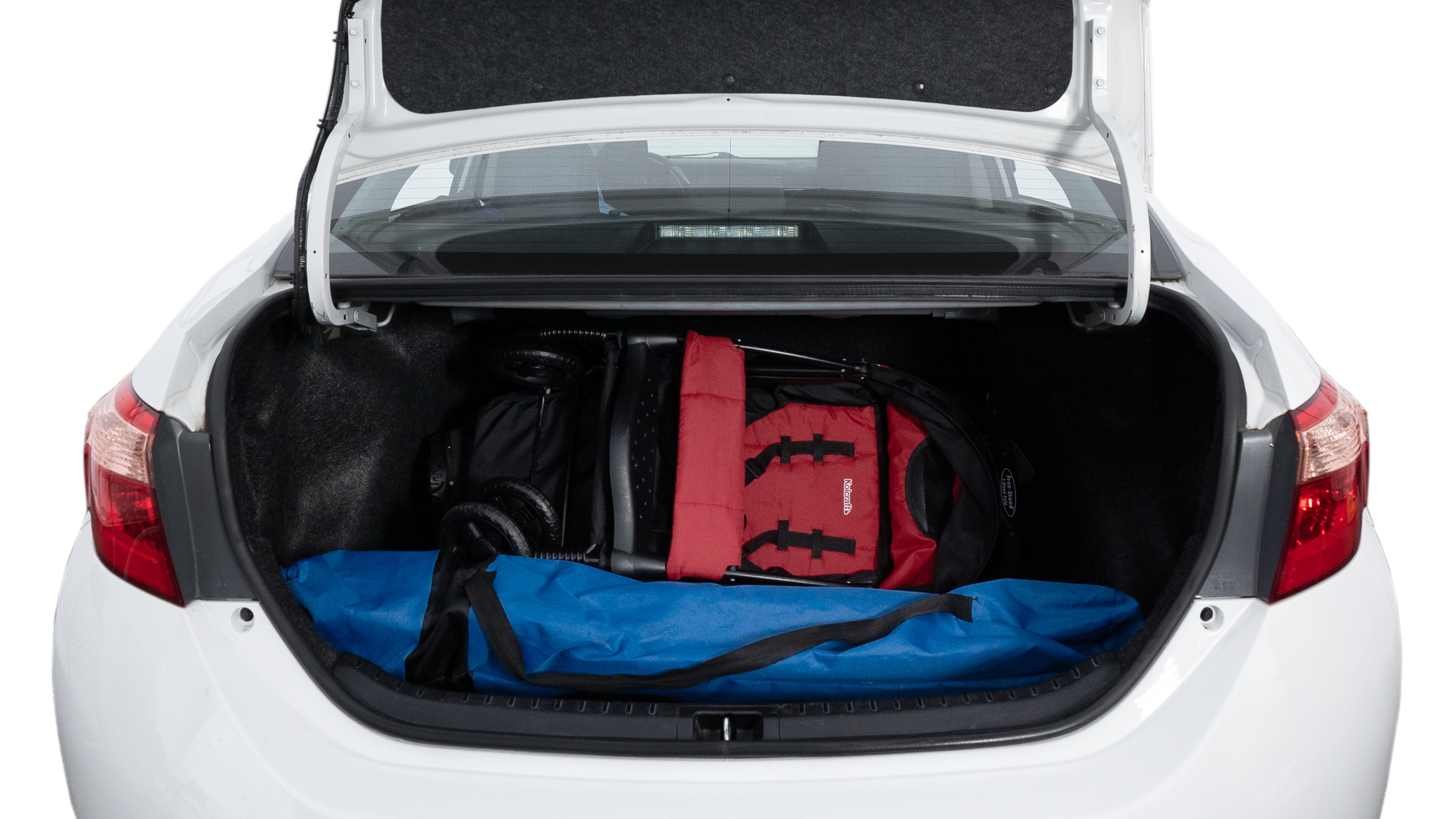 The trunk lid is open showing full view of the trunk. A baby stroller, three grocery carriers, two camping chairs in the carrying bag, and a set of golf clubs are placed inside.