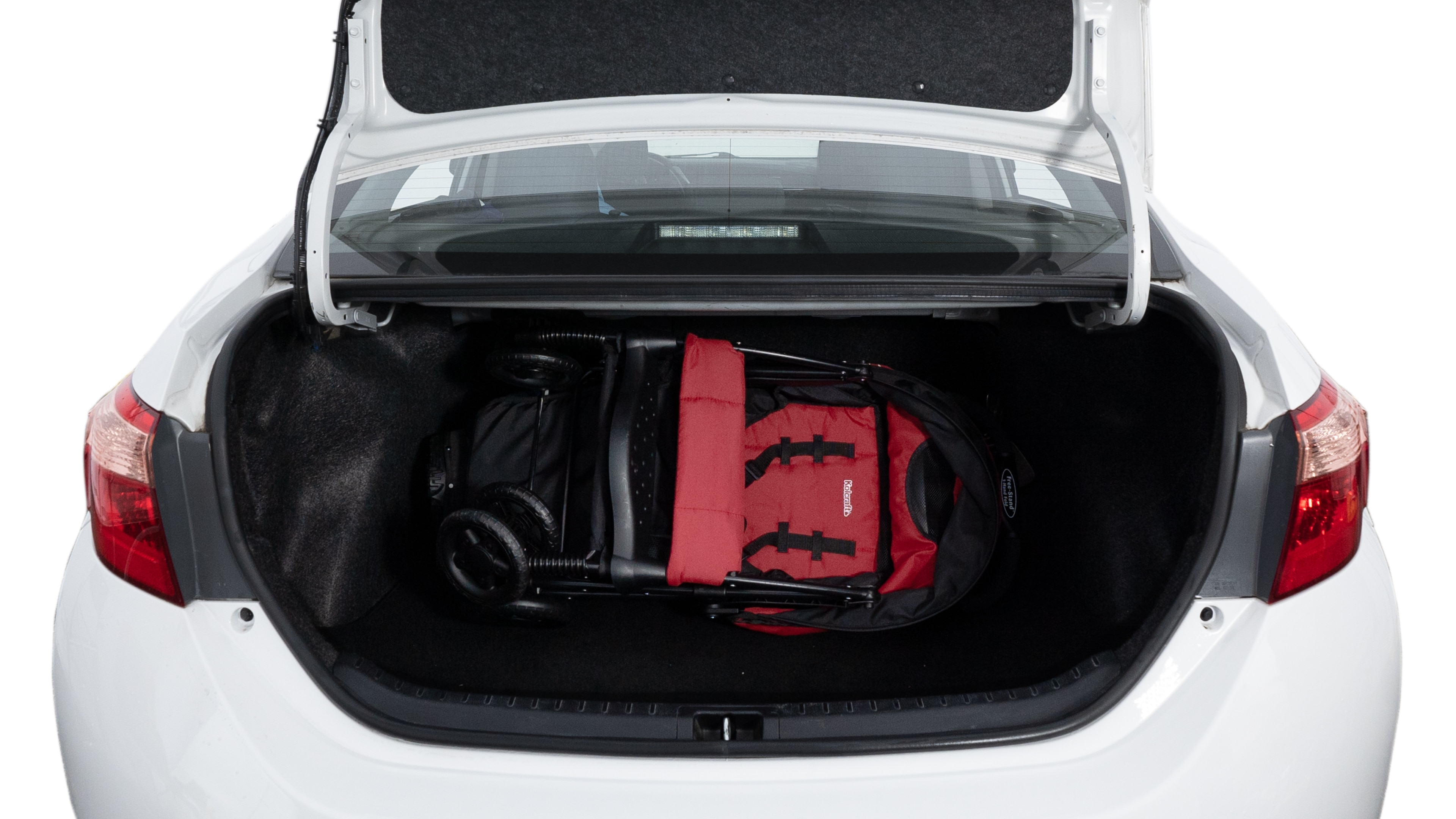 The trunk lid is open showing full view of the trunk. A baby stroller, three grocery carriers, two camping chairs in the carrying bag, and a set of golf clubs are placed inside.