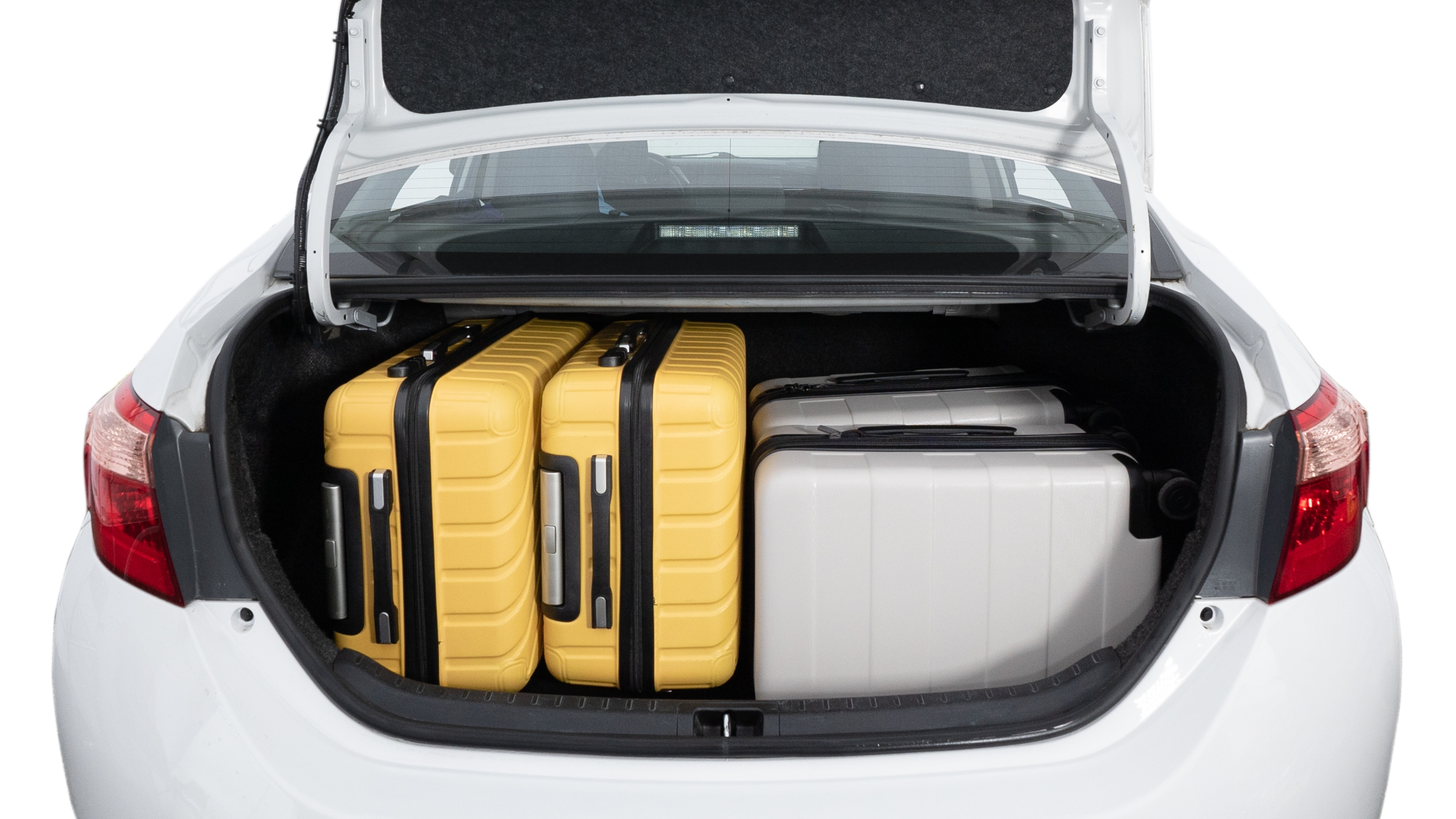 The trunk lid is open, showing a full view of the trunk space. Two medium and two small suitcases are placed inside