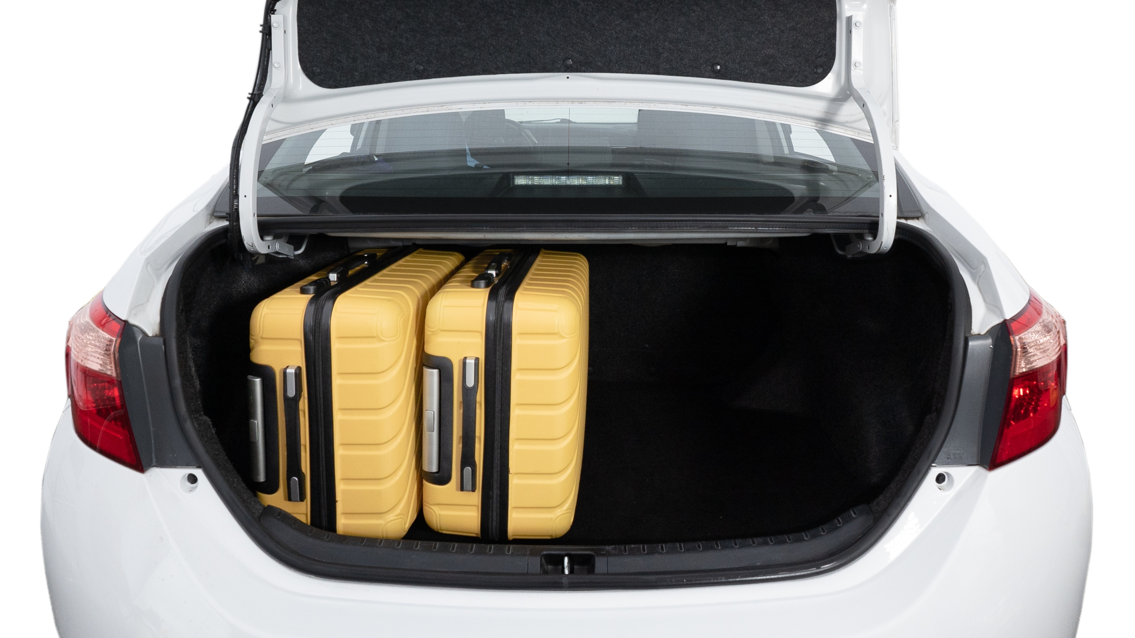 The trunk lid is open, showing a full view of the trunk space. Two medium and two small suitcases are placed inside