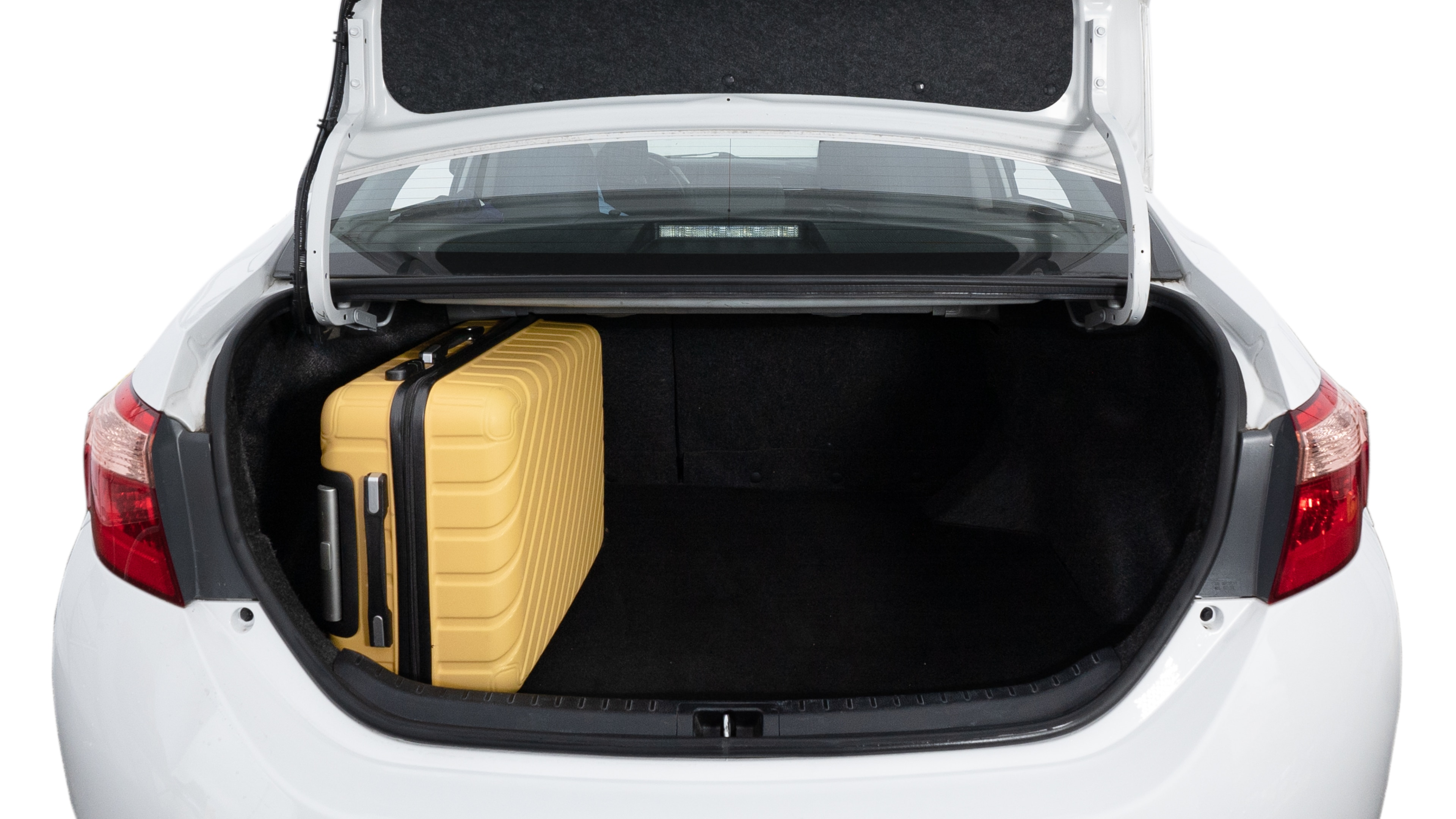 The trunk lid is open, showing a full view of the trunk space. Two medium and two small suitcases are placed inside