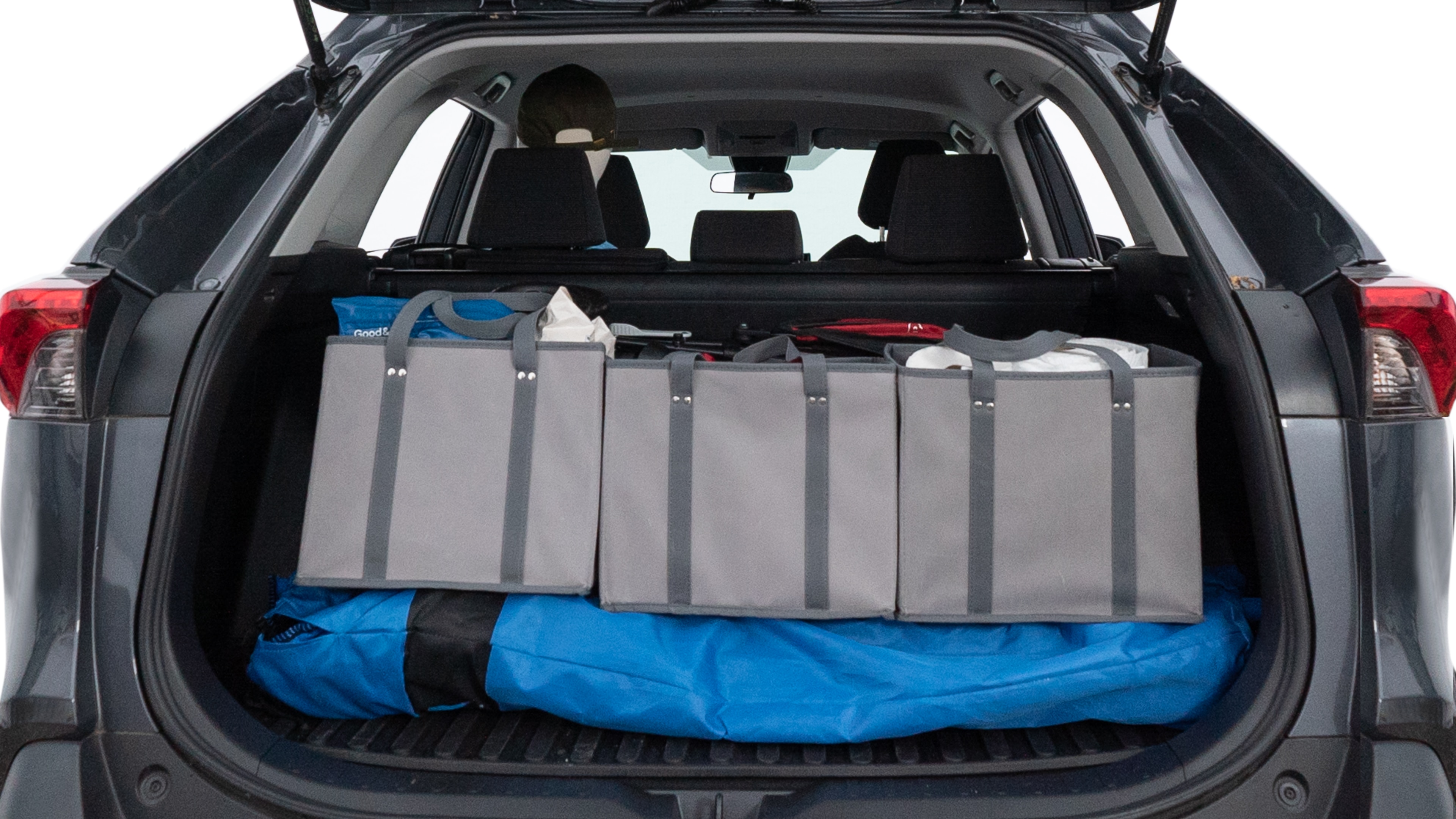 The trunk lid is open showing full view of the trunk. A baby stroller, three grocery carriers, two camping chairs in the carrying bag, and a set of golf clubs are placed inside.