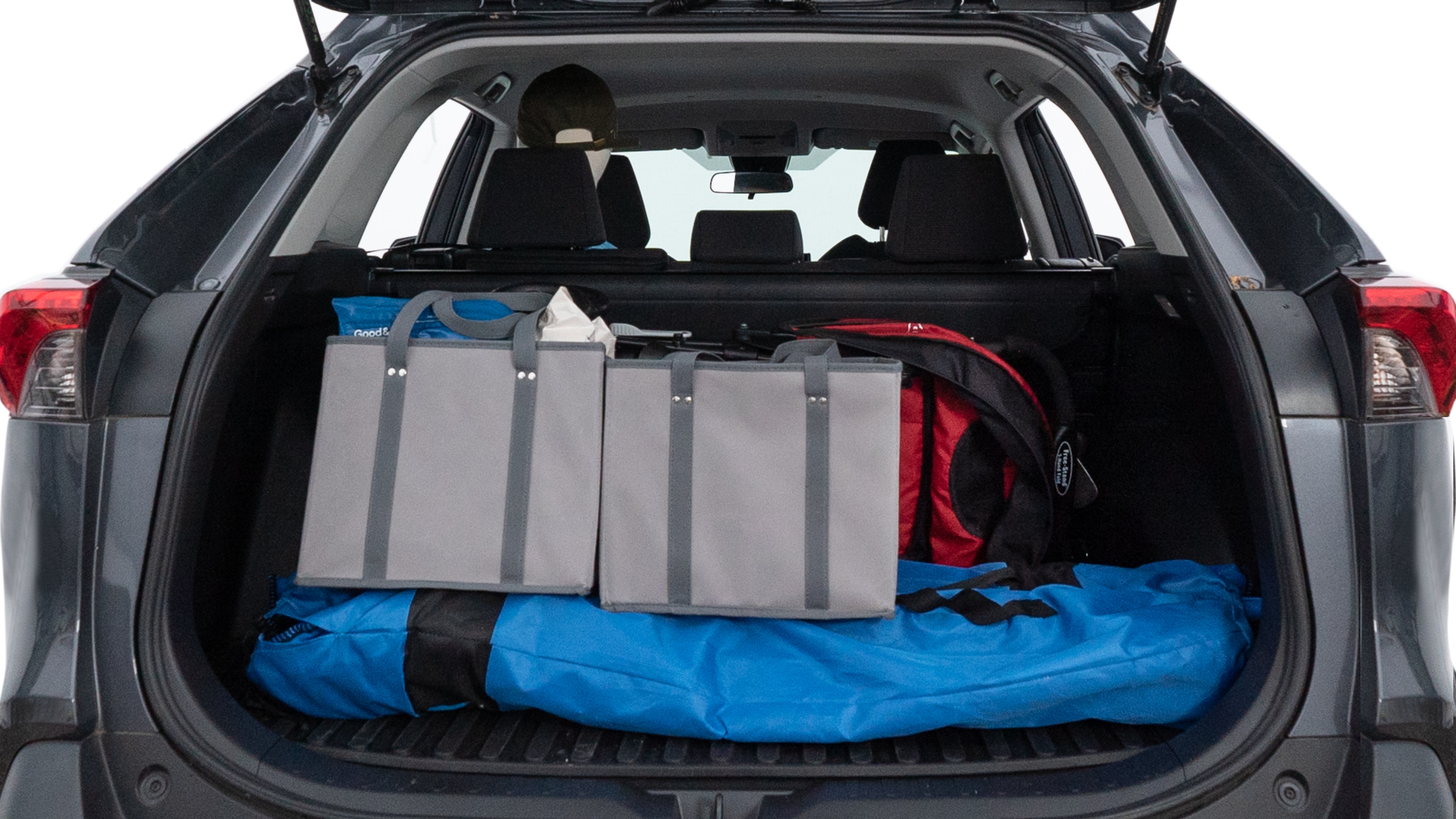 The trunk lid is open showing full view of the trunk. A baby stroller, three grocery carriers, two camping chairs in the carrying bag, and a set of golf clubs are placed inside.