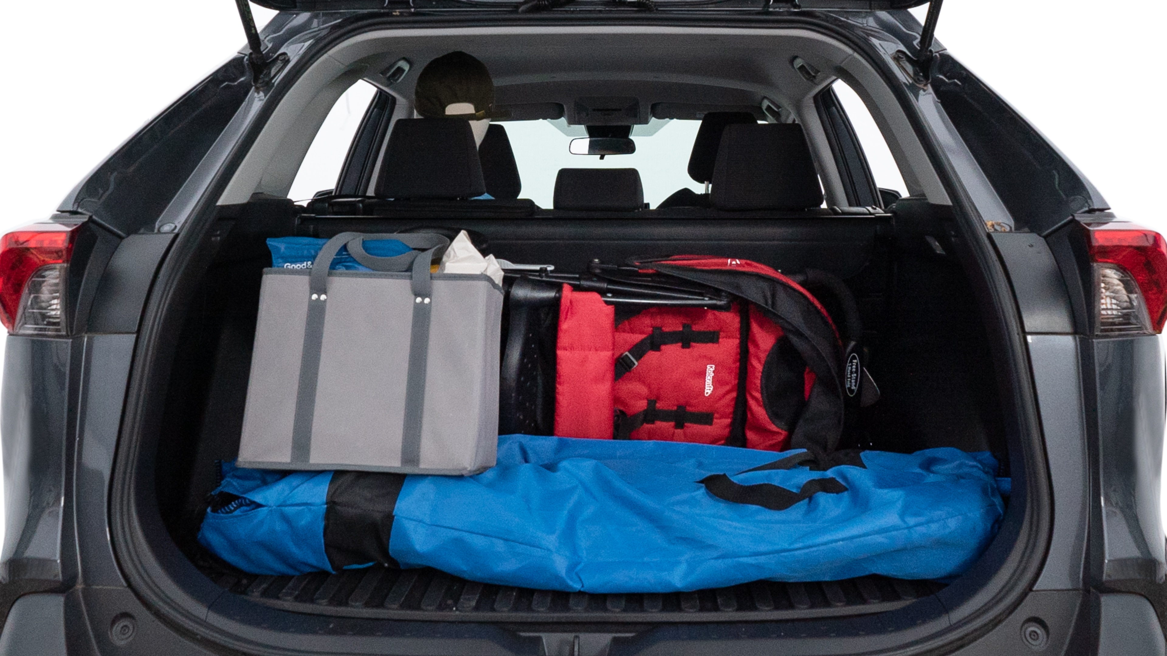 The trunk lid is open showing full view of the trunk. A baby stroller, three grocery carriers, two camping chairs in the carrying bag, and a set of golf clubs are placed inside.
