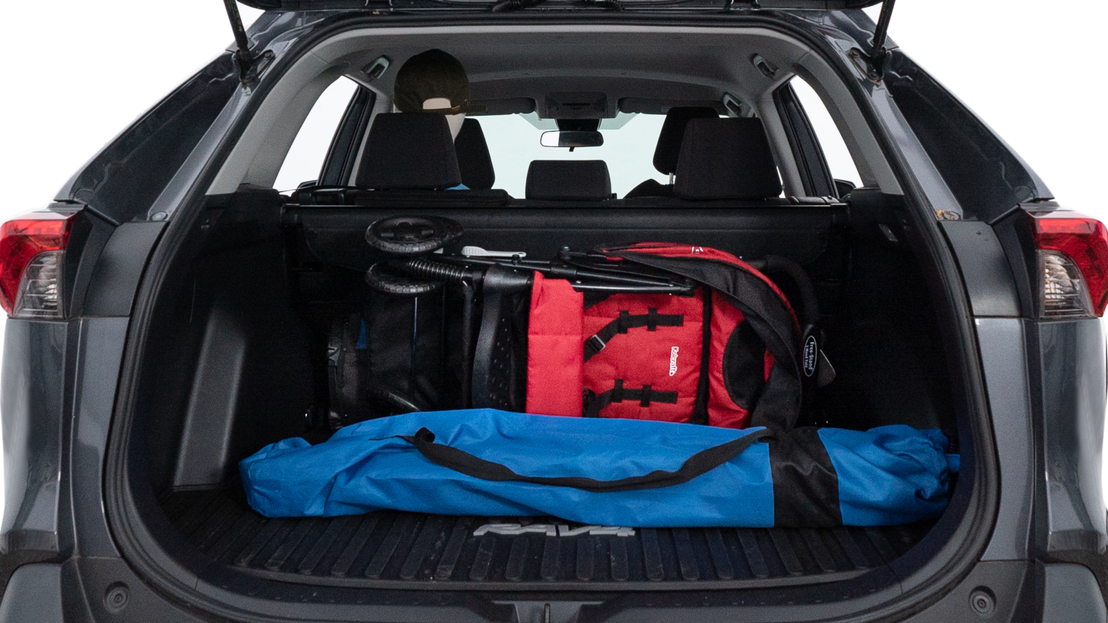 The trunk lid is open showing full view of the trunk. A baby stroller, three grocery carriers, two camping chairs in the carrying bag, and a set of golf clubs are placed inside.