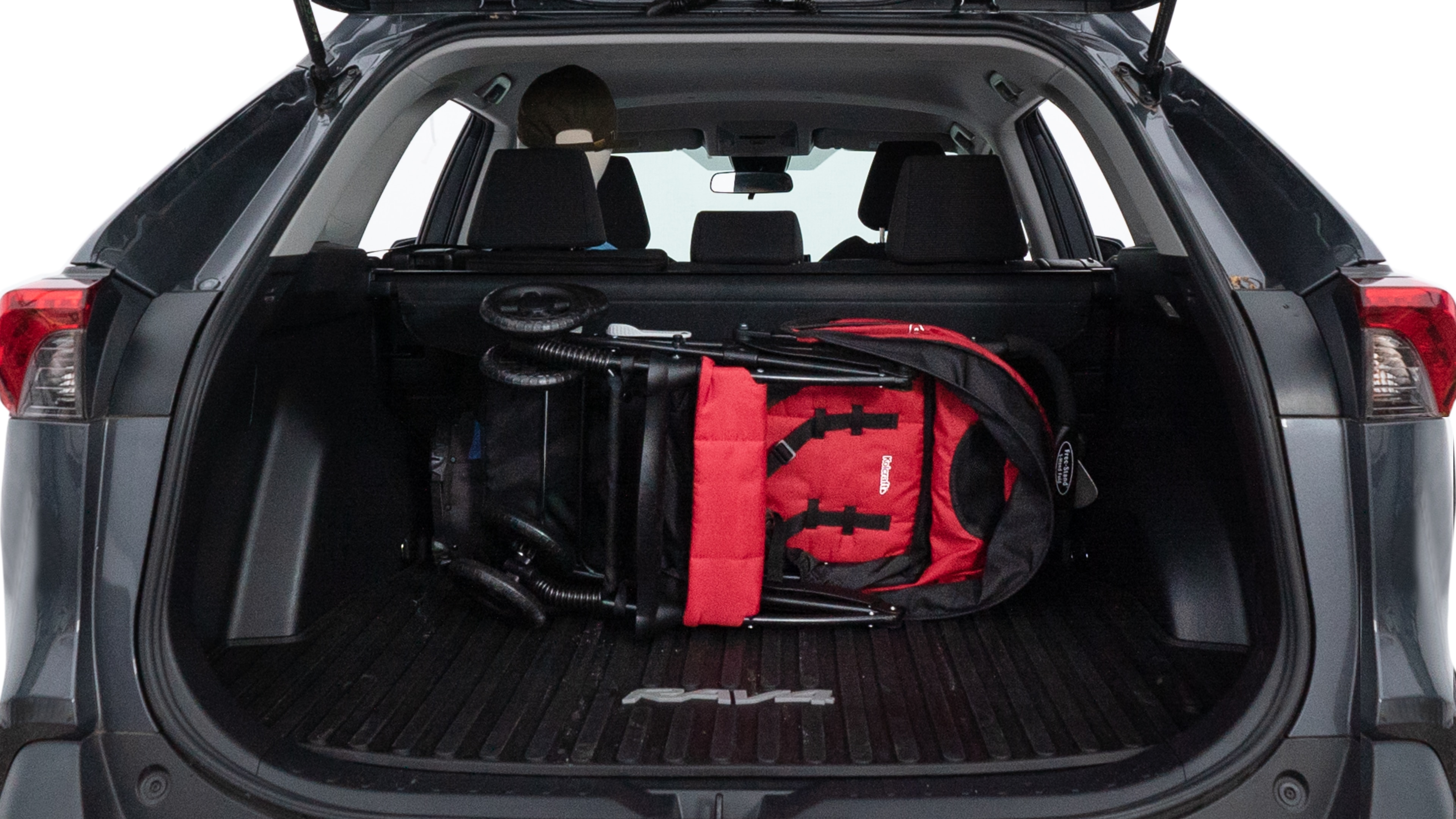 The trunk lid is open showing full view of the trunk. A baby stroller, three grocery carriers, two camping chairs in the carrying bag, and a set of golf clubs are placed inside.