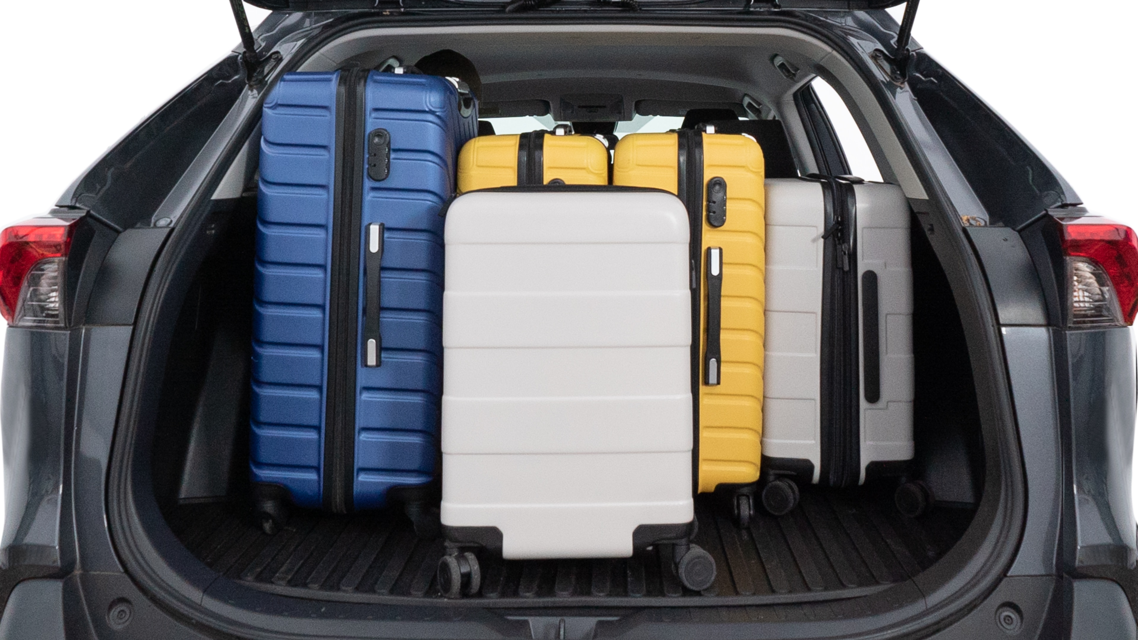 The trunk lid is open, showing full view of the trunk space. One large, two medium, and two small suitcases are placed inside.