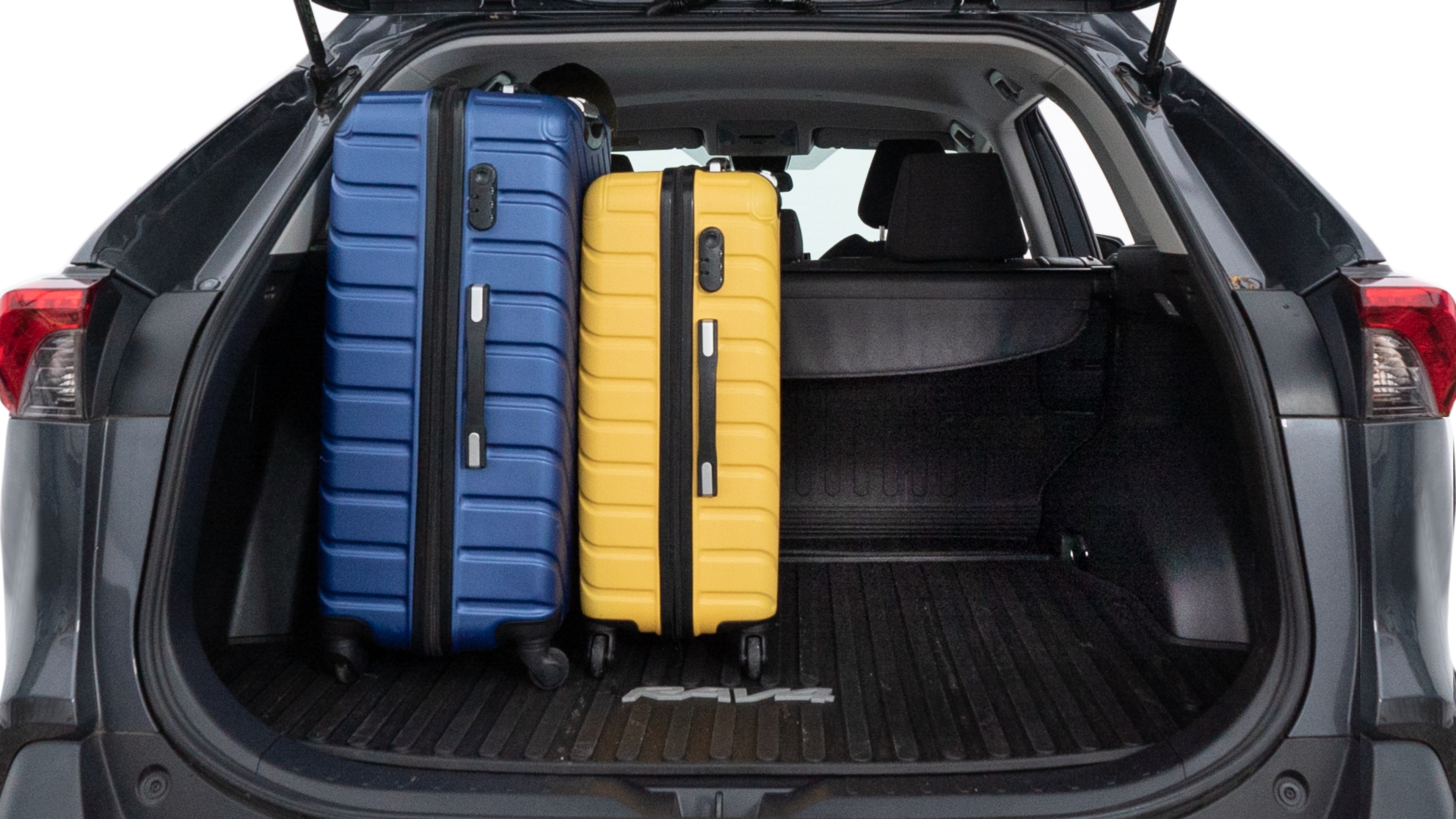 The trunk lid is open, showing full view of the trunk space. One large, two medium, and two small suitcases are placed inside.