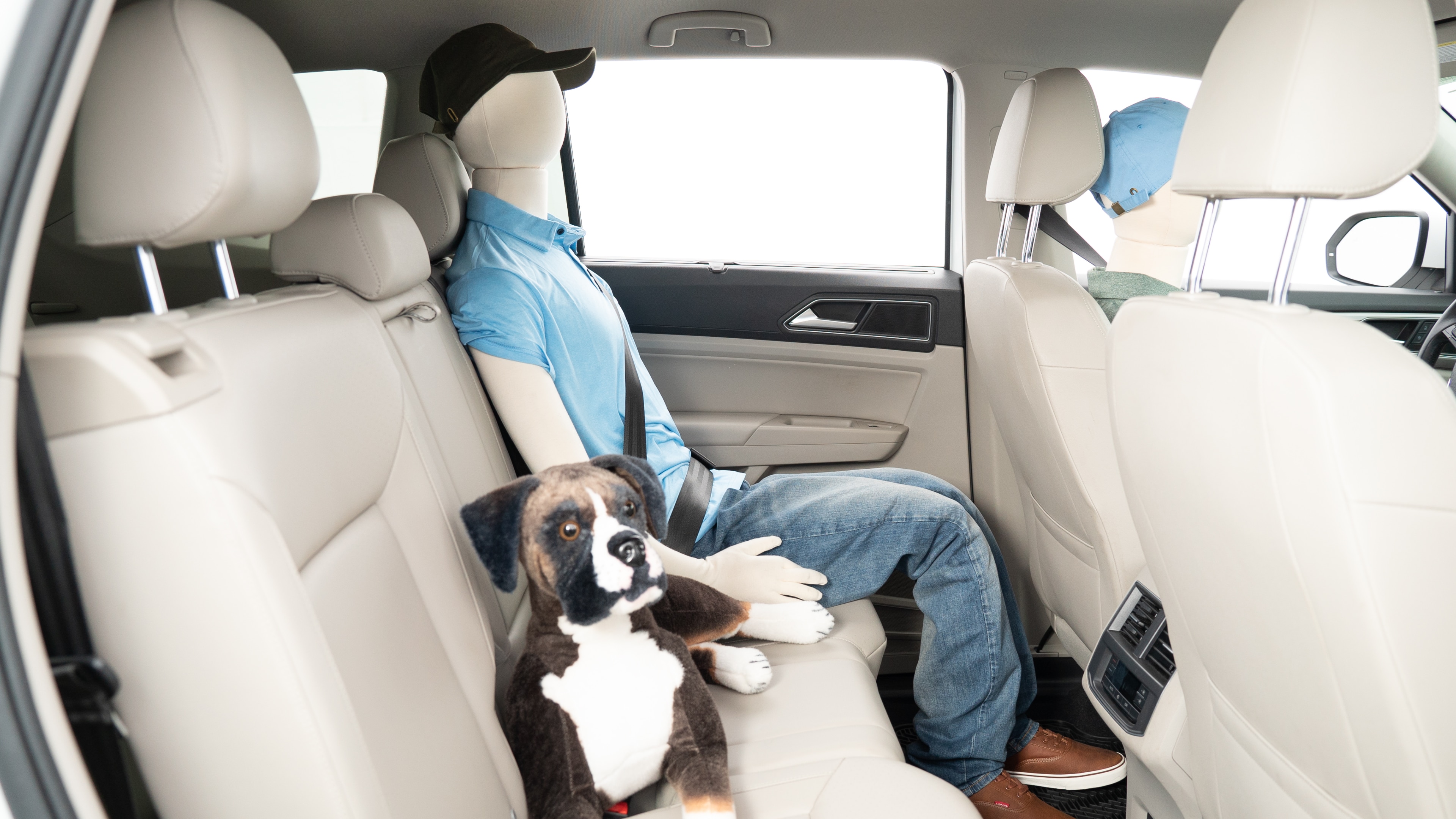 A series of second-row backseat photos is shown including one seating a baby seat, a dog and one seating a 6'1" mannequin.