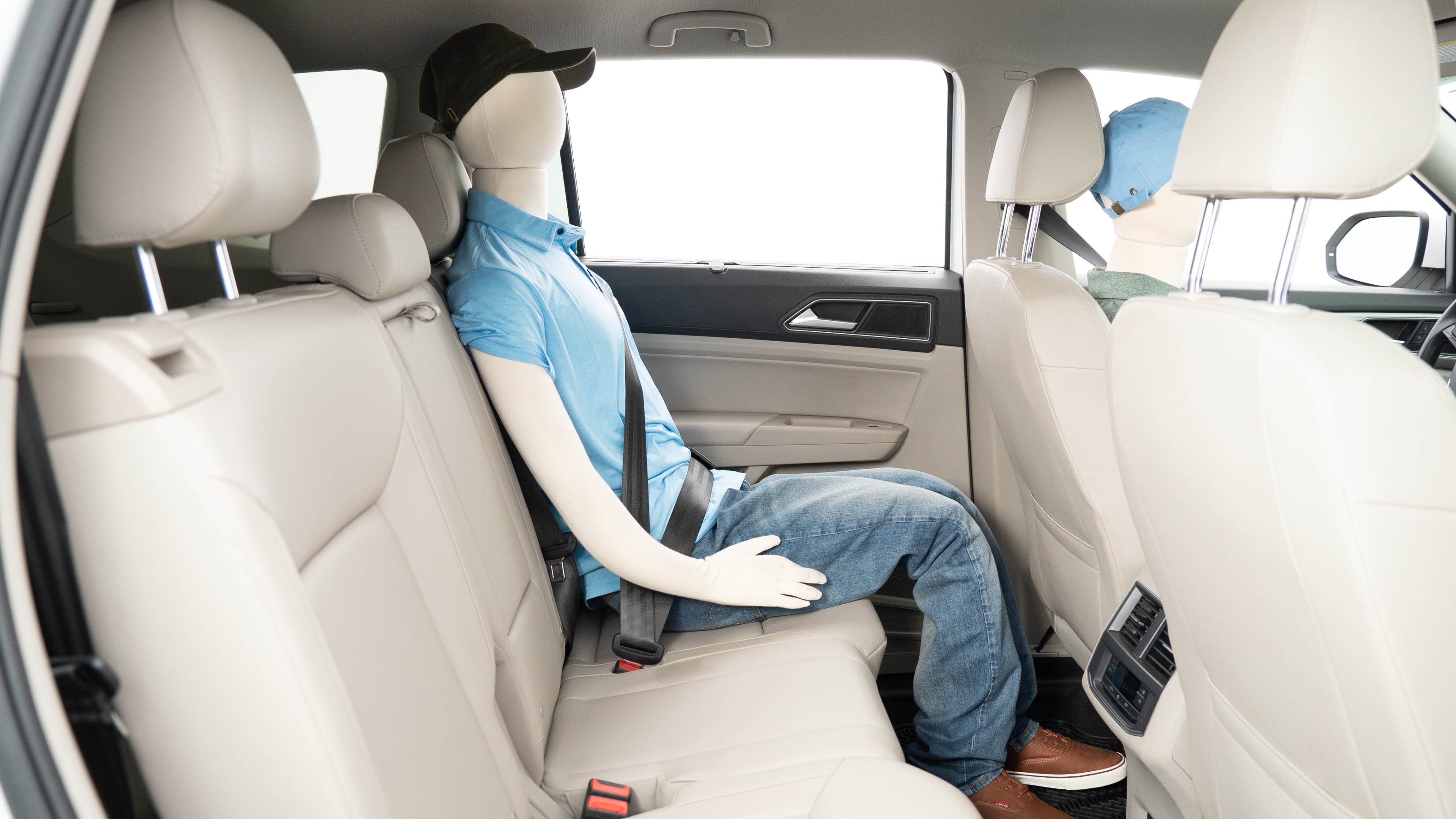 A series of second-row backseat photos is shown including one seating a baby seat, a dog and one seating a 6'1" mannequin.