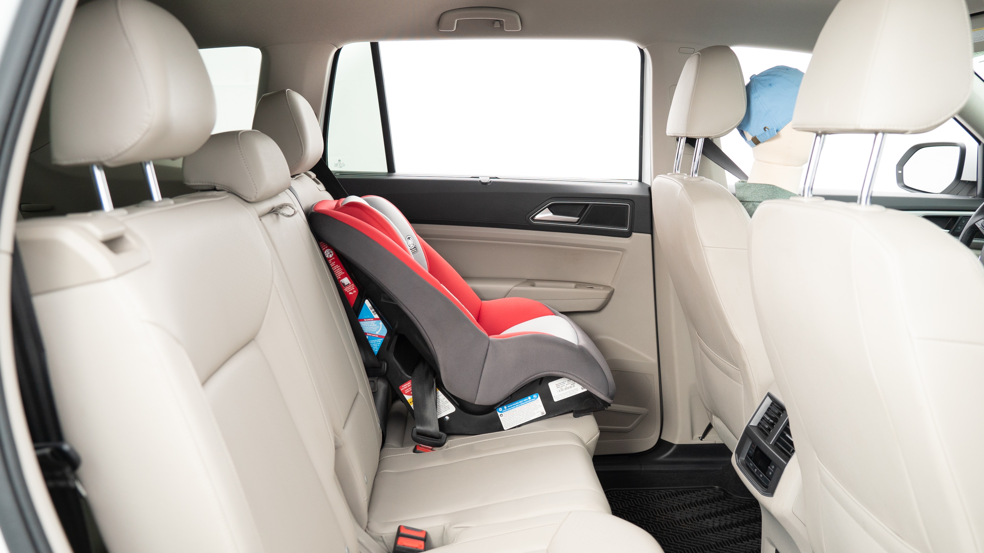 A series of second-row backseat photos is shown including one seating a baby seat, a dog and one seating a 6'1" mannequin.
