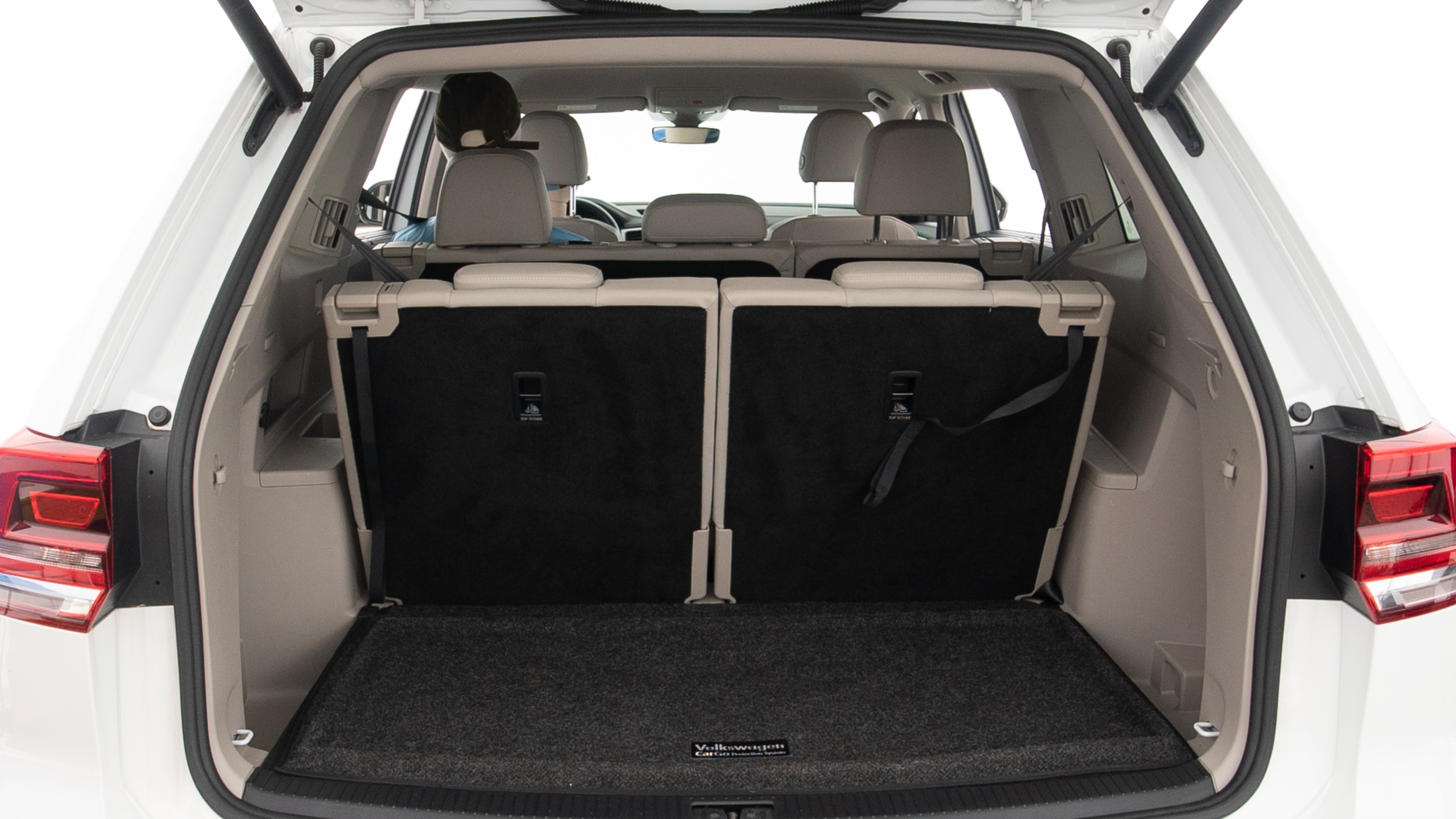 The trunk lid is open, showing full view of the trunk space. Two large and one small suitcases are placed inside.