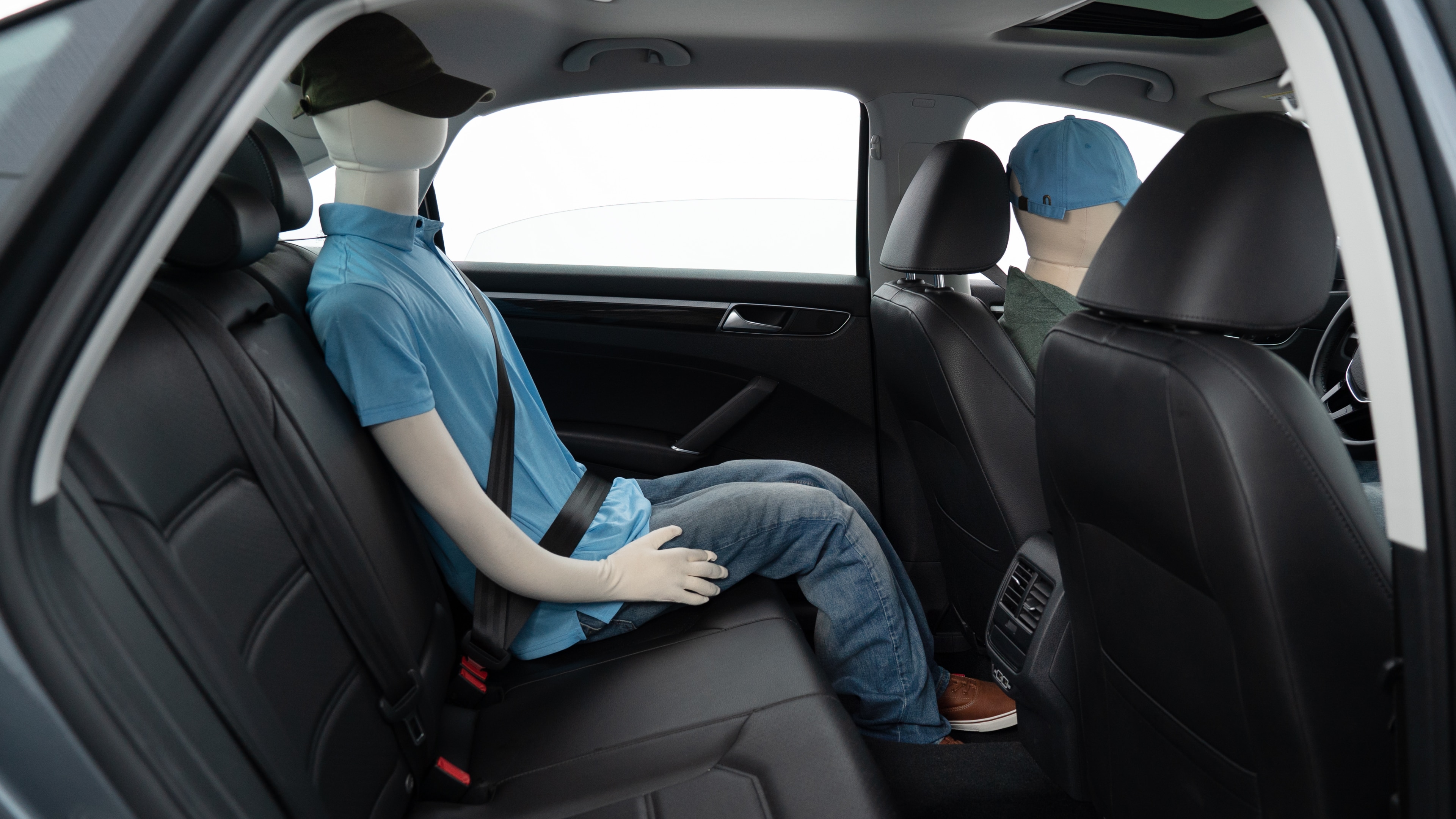 A series of second-row backseat photos is shown including one seating a baby seat, a dog and one seating a 6'1" mannequin.
