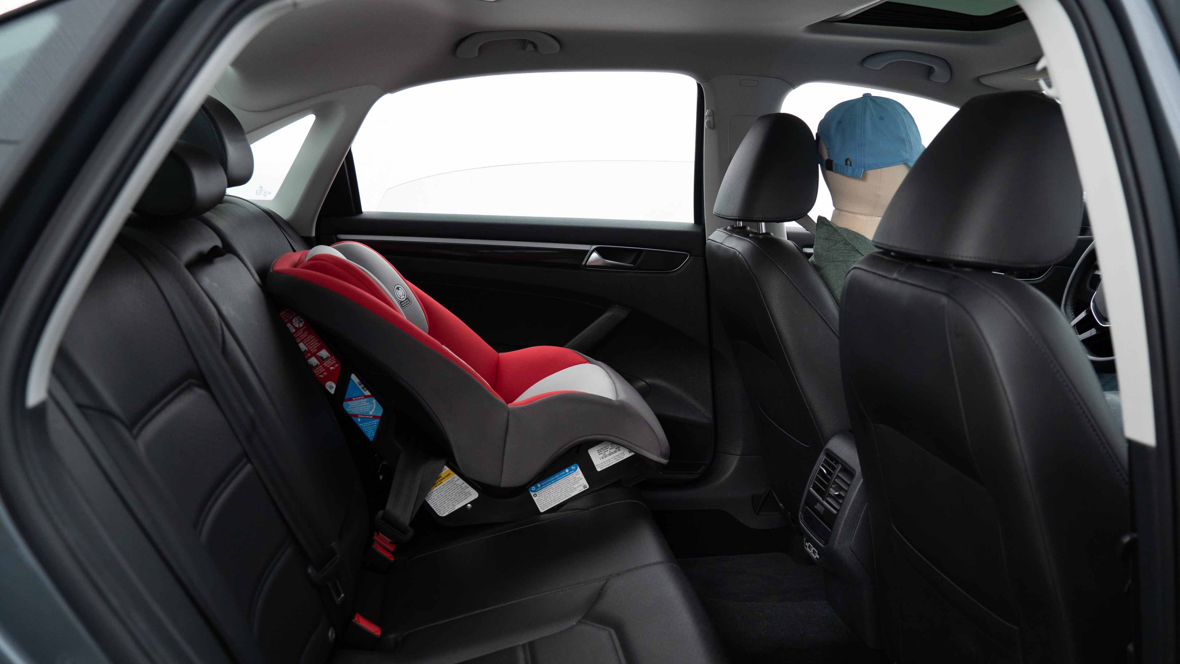 A series of second-row backseat photos is shown including one seating a baby seat, a dog and one seating a 6'1" mannequin.