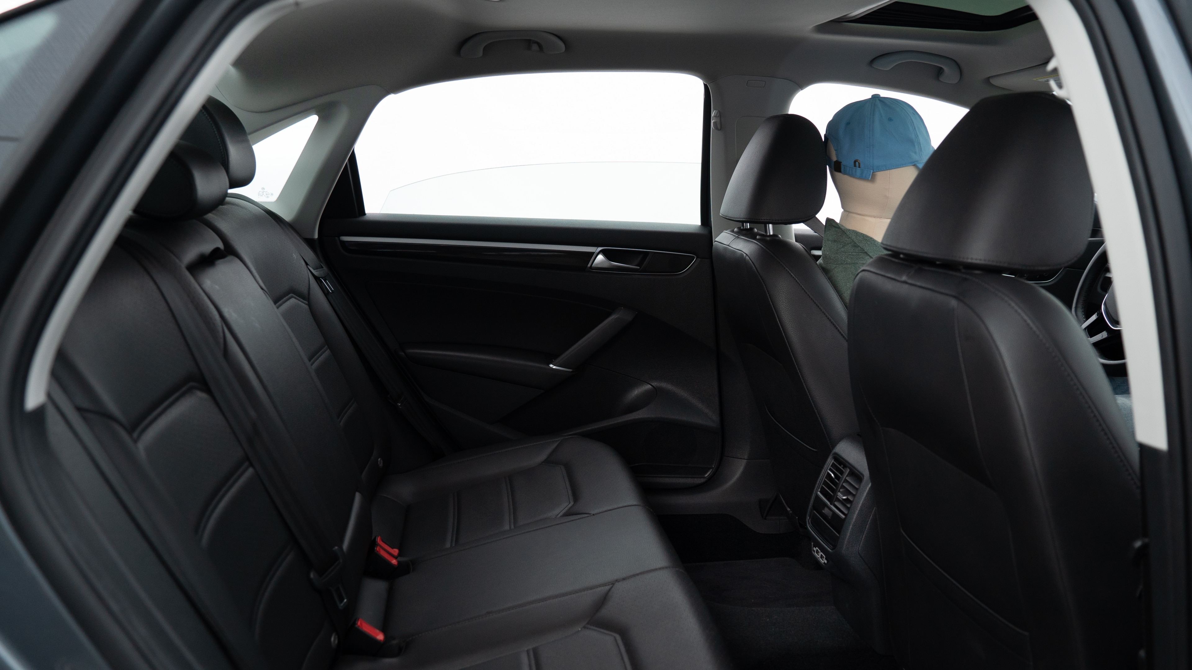 A series of second-row backseat photos is shown including one seating a baby seat, a dog and one seating a 6'1" mannequin.