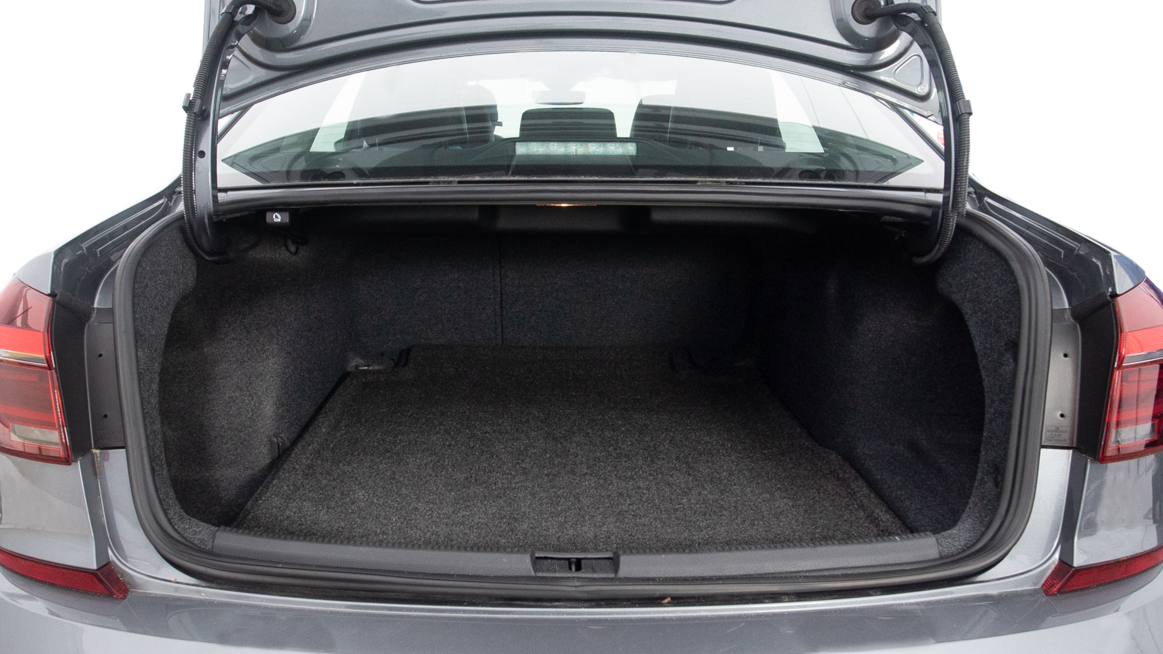 The trunk lid is open, showing full view of the trunk space. Three large and one small suitcases are placed inside.