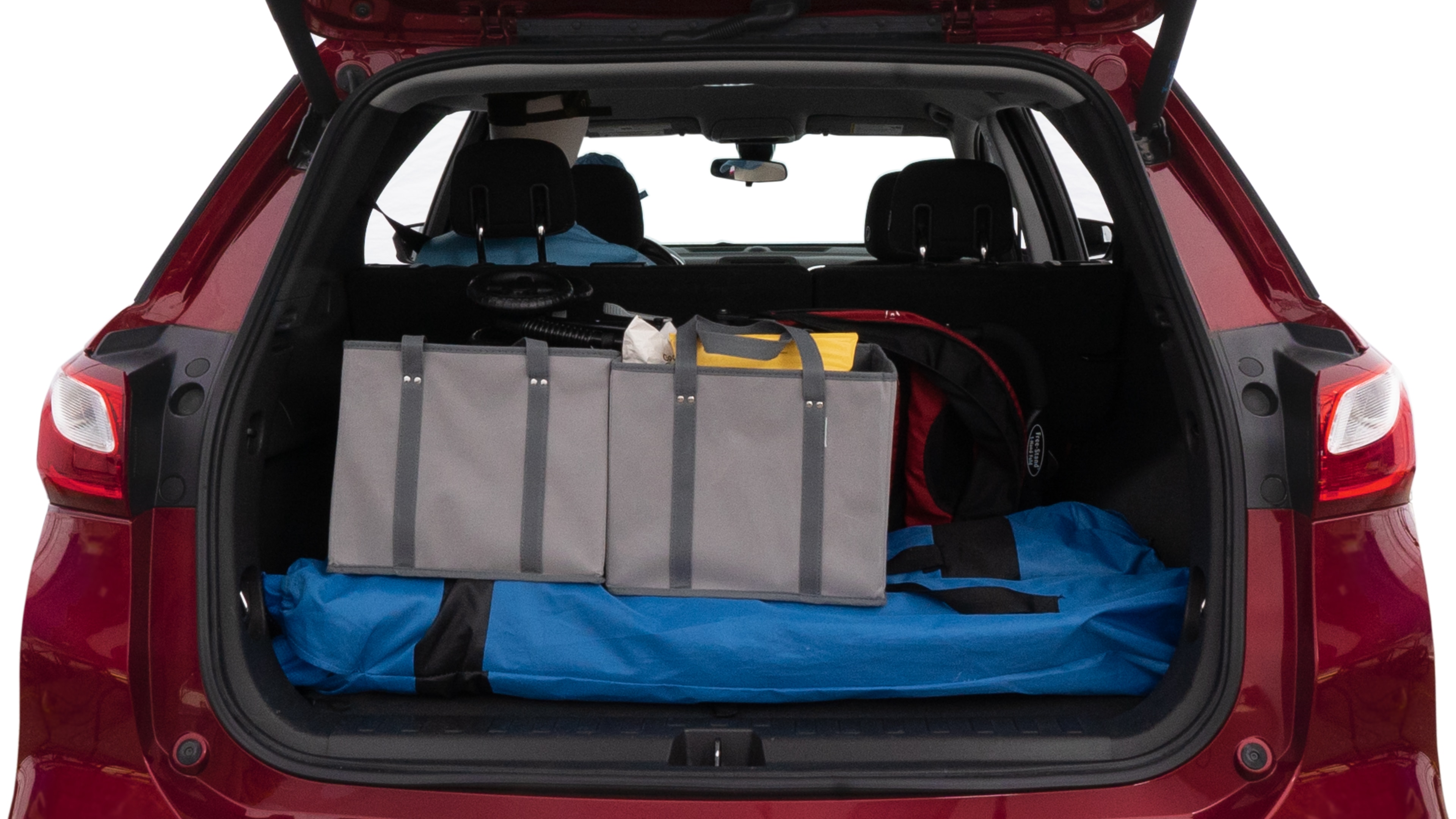 The trunk lid is open showing full view of the trunk. A baby stroller, three grocery carriers, two camping chairs in the carrying bag, and a set of golf clubs are placed inside.