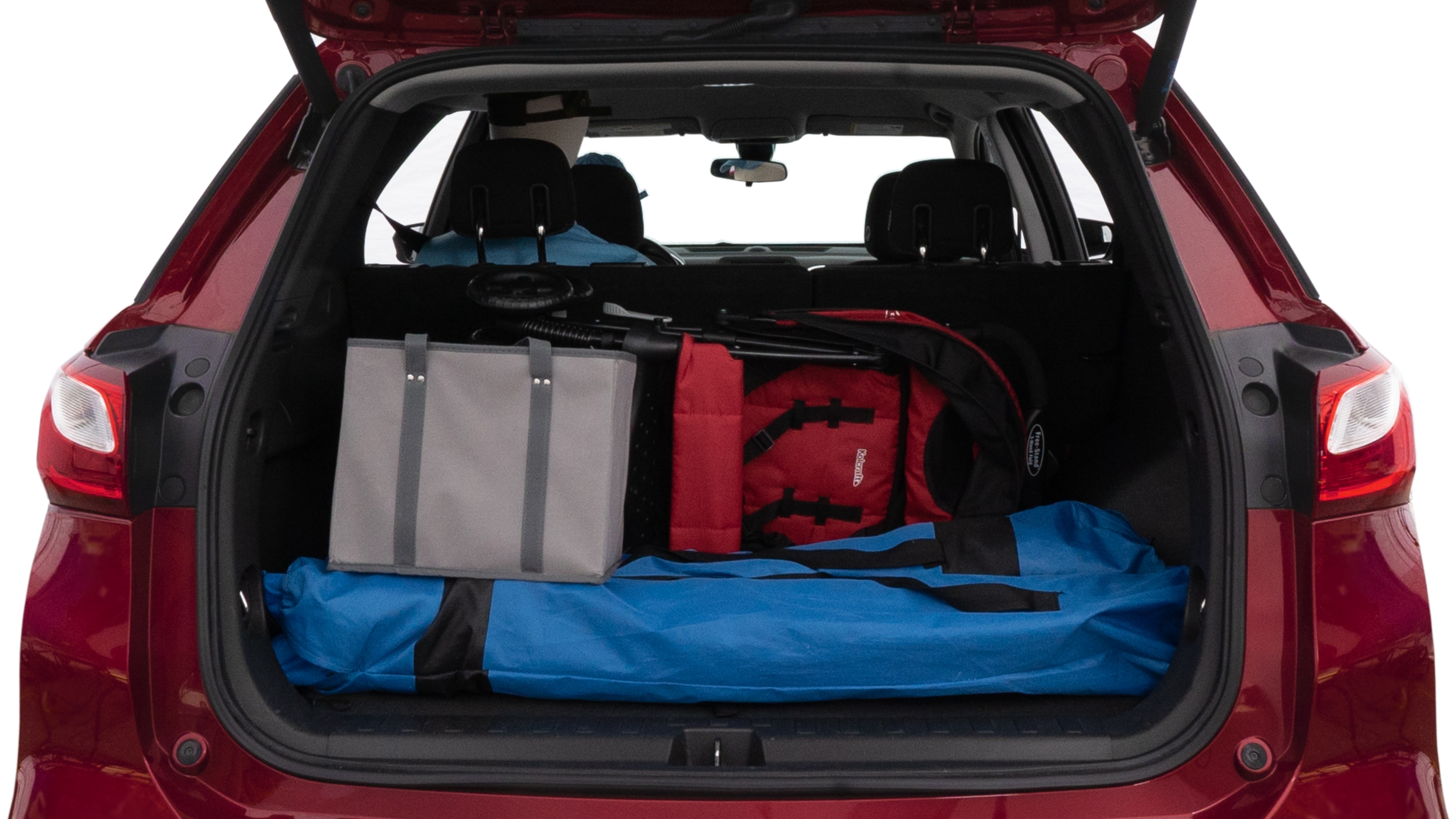 The trunk lid is open showing full view of the trunk. A baby stroller, three grocery carriers, two camping chairs in the carrying bag, and a set of golf clubs are placed inside.
