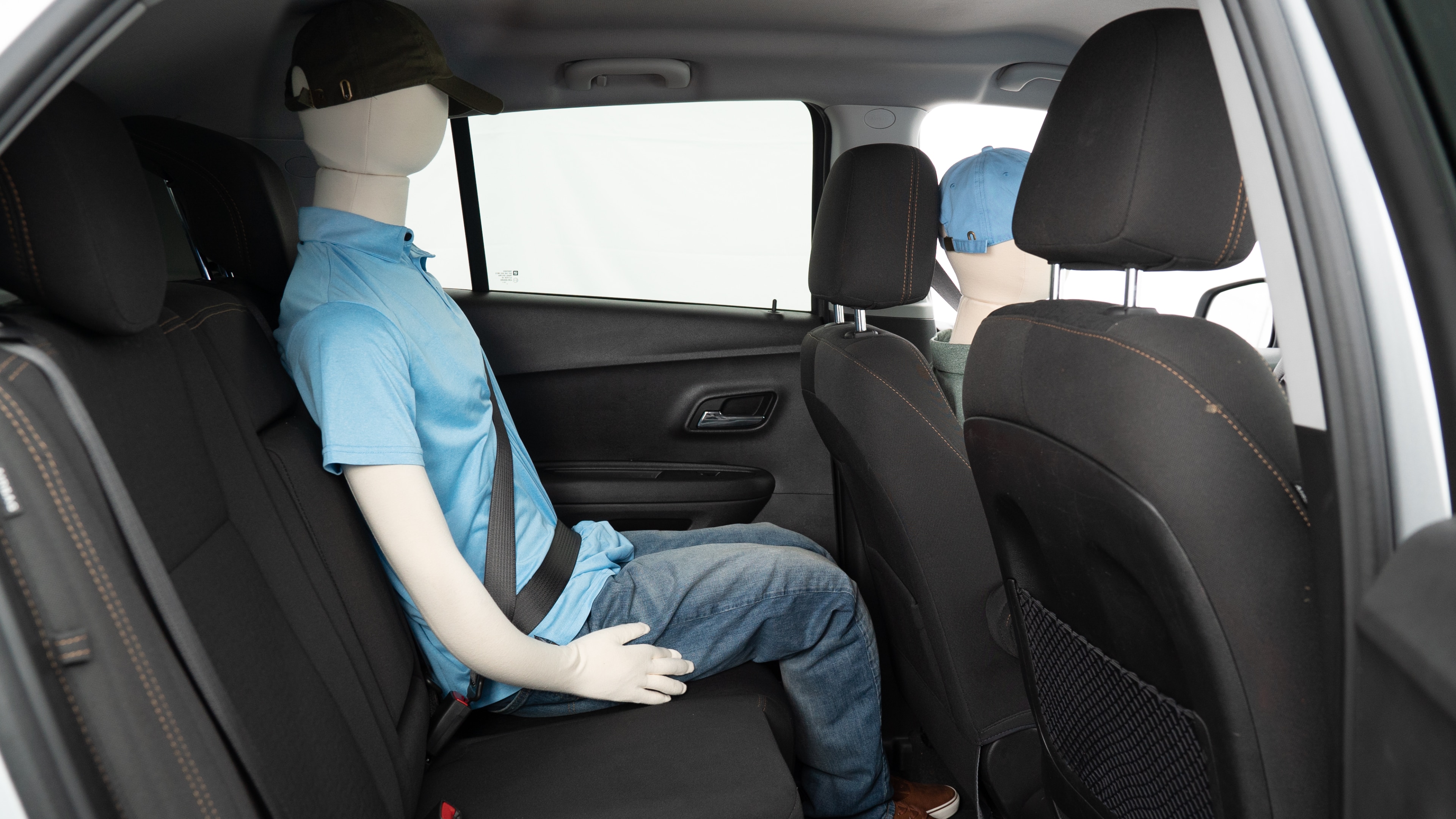 A series of second-row backseat photos is shown including one seating a baby seat, a dog and one seating a 6'1" mannequin.