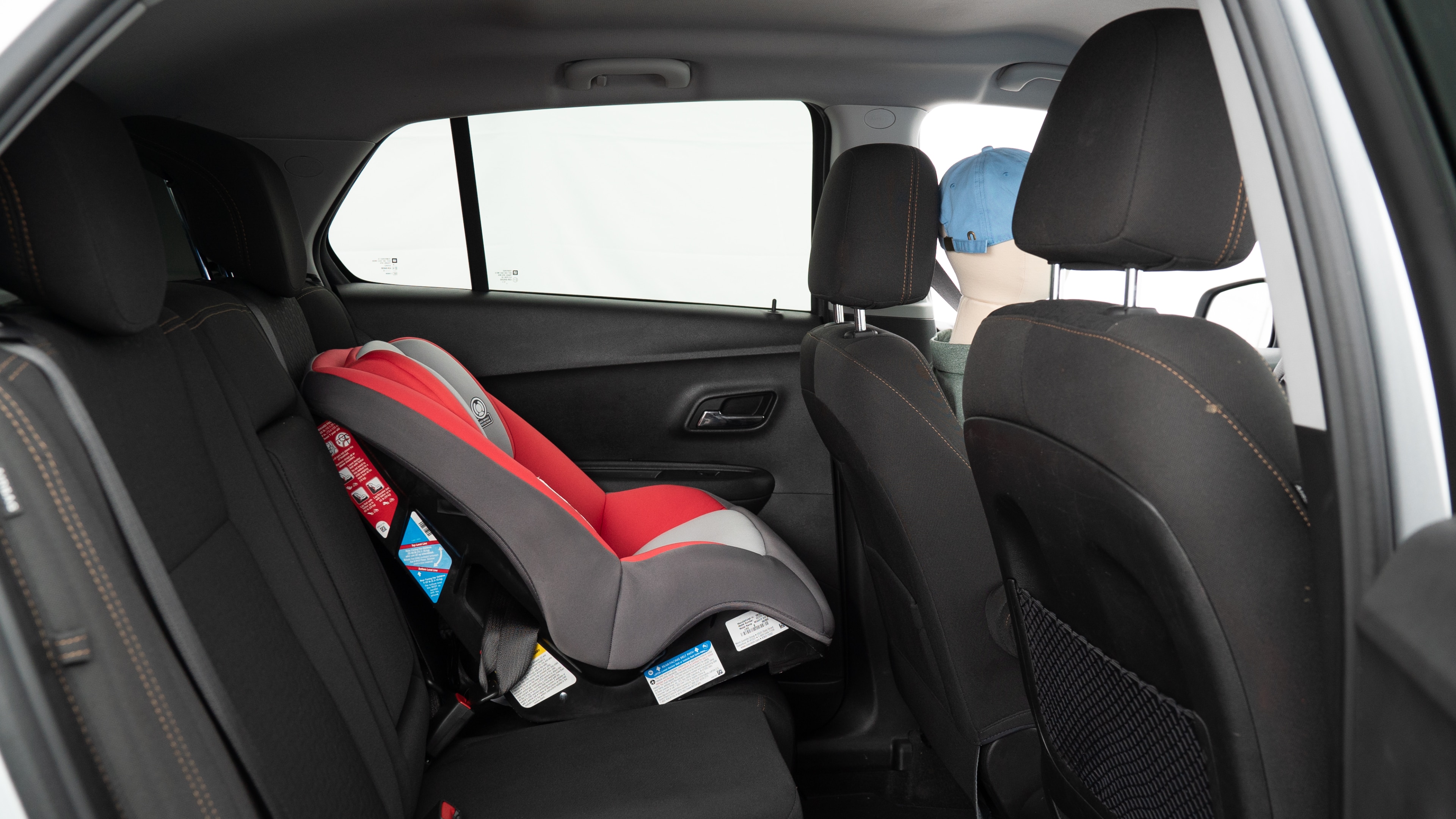 A series of second-row backseat photos is shown including one seating a baby seat, a dog and one seating a 6'1" mannequin.