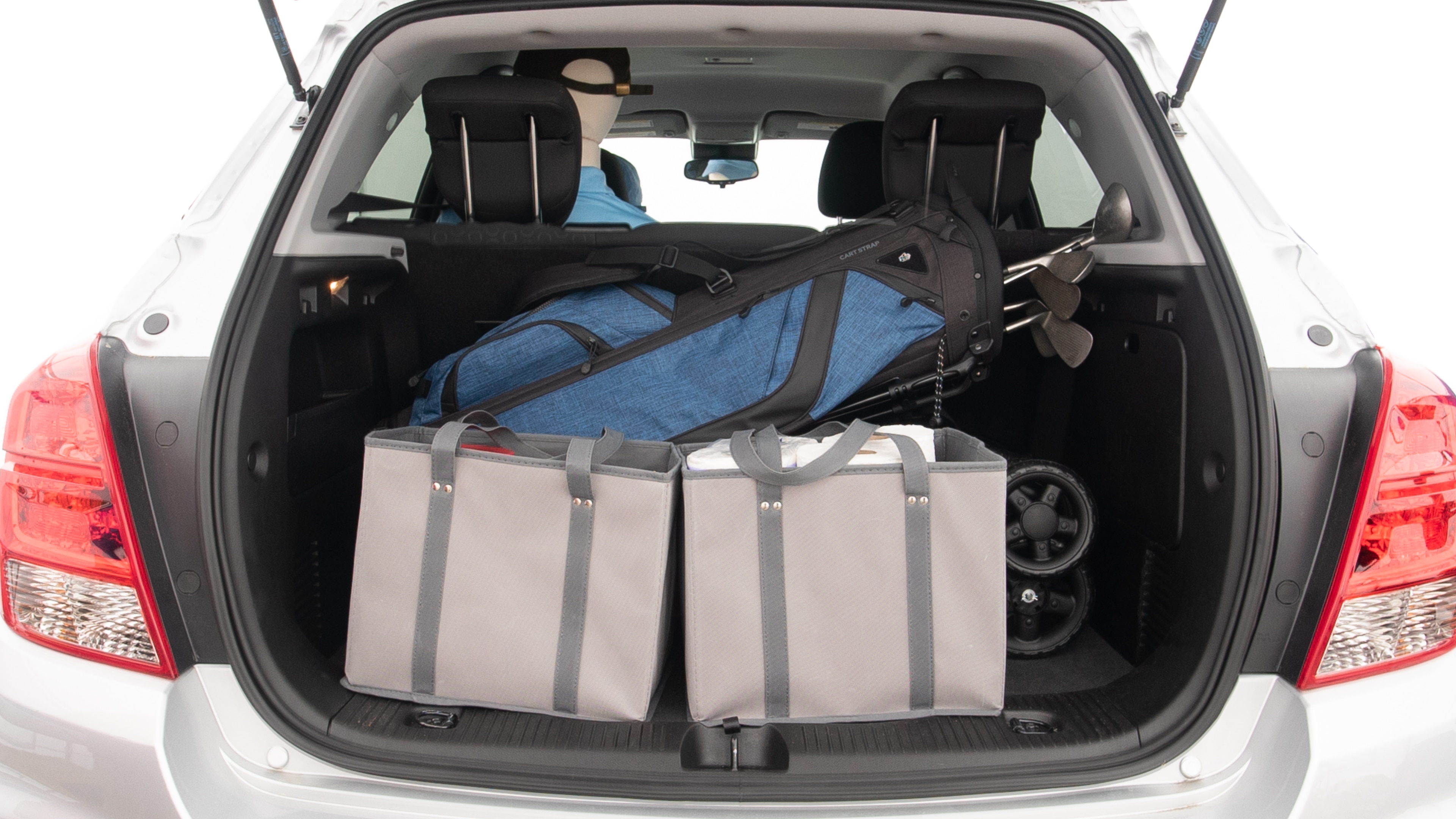 The trunk lid is open showing full view of the trunk. A baby stroller, three grocery carriers and a set of golf clubs are placed inside.