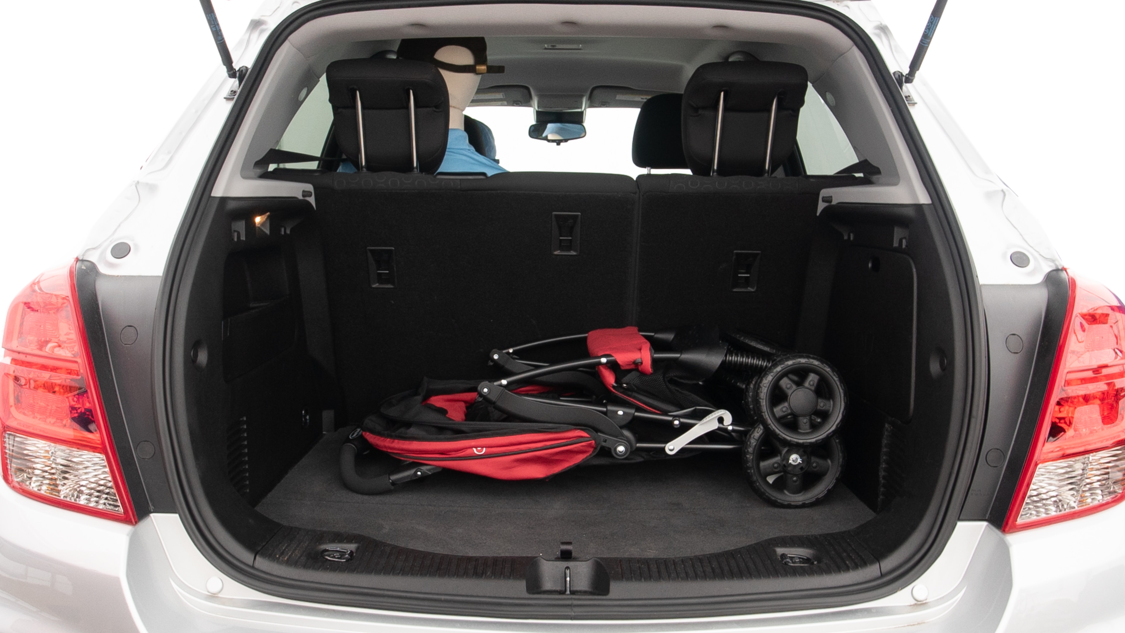 The trunk lid is open showing full view of the trunk. A baby stroller, three grocery carriers and a set of golf clubs are placed inside.
