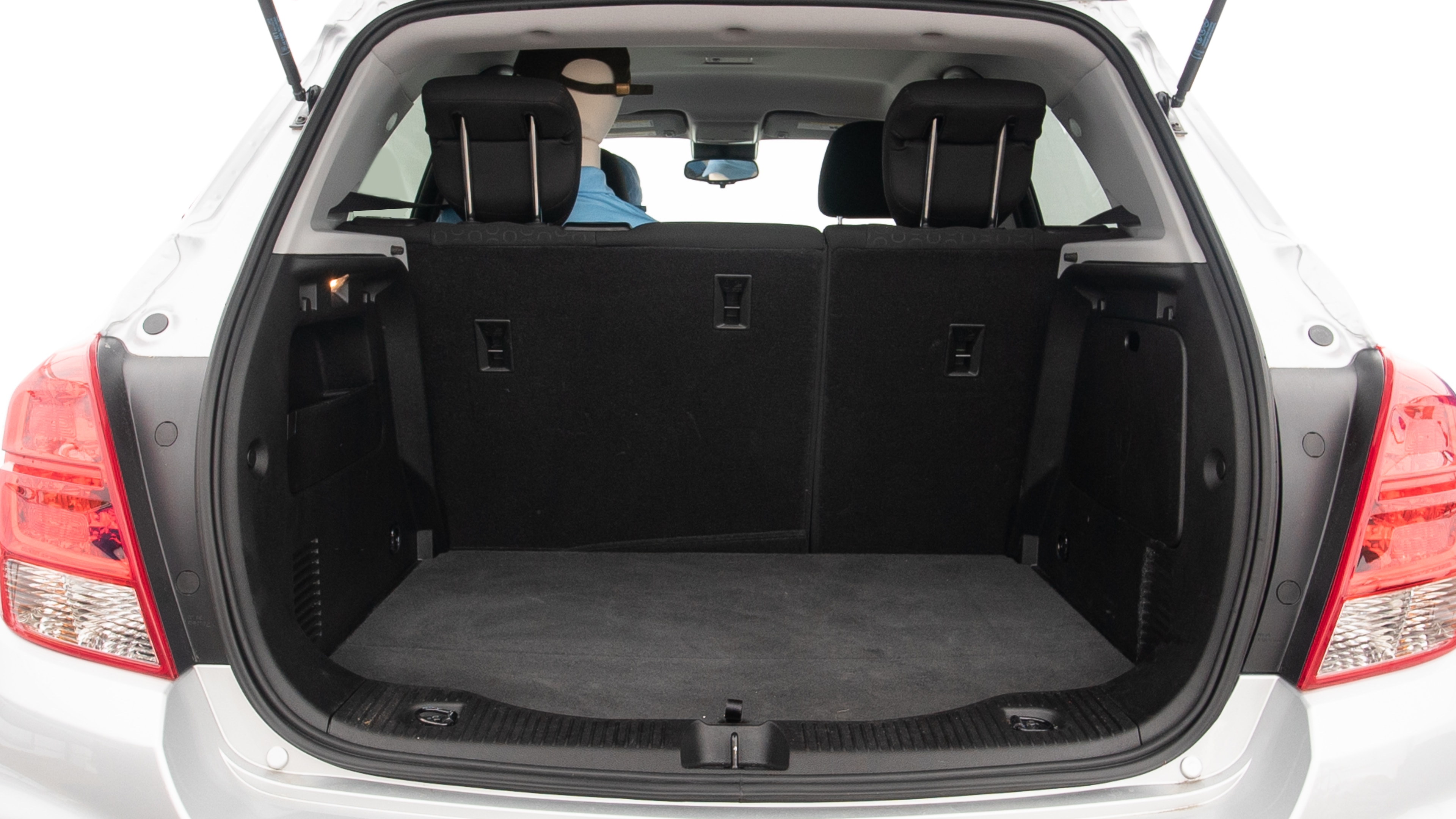 The trunk lid is open, showing full view of the trunk space. Two large and two small suitcases are placed inside.