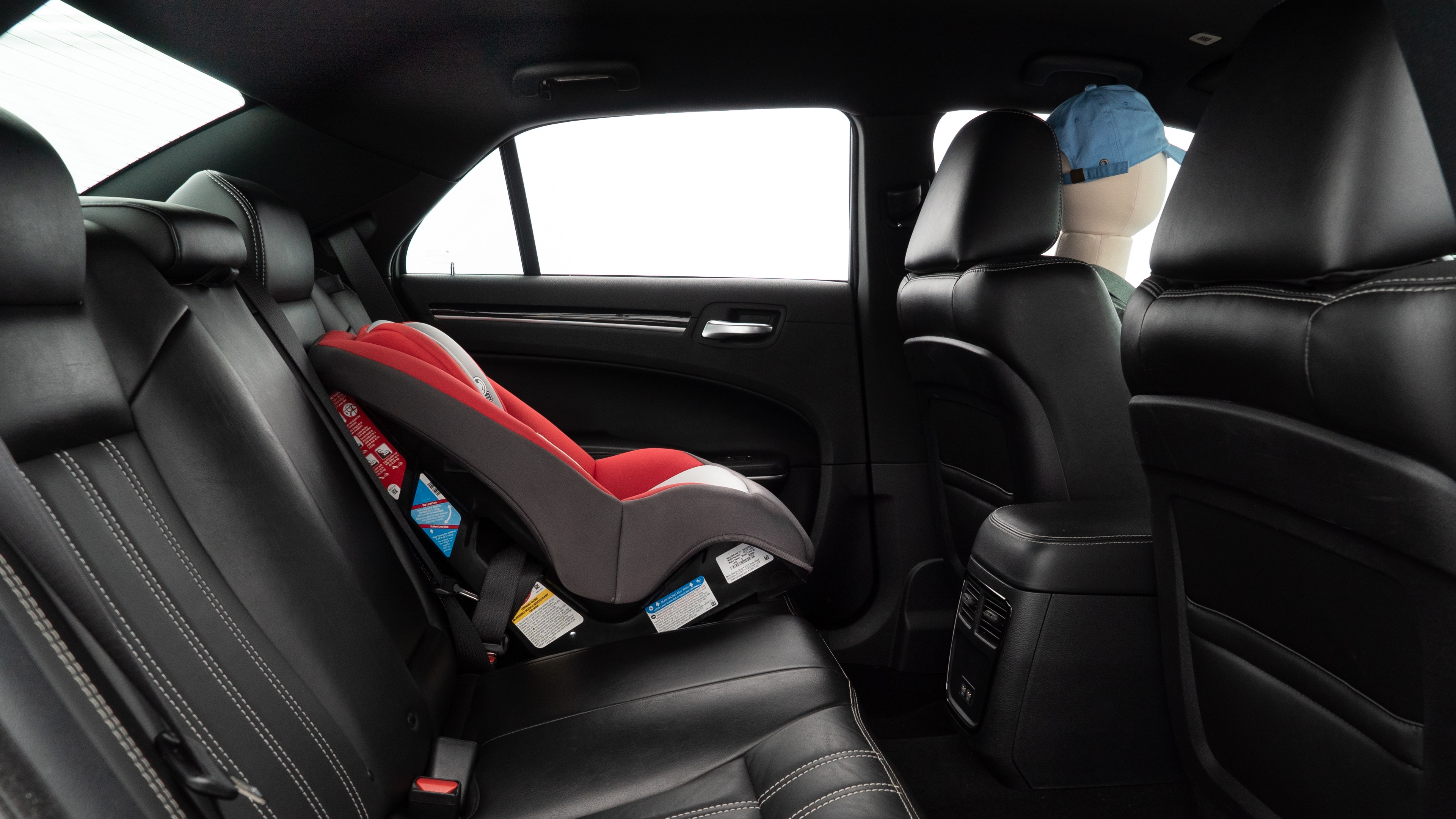 A series of second-row backseat photos is shown including one seating a baby seat and one seating a 6'1" mannequin.