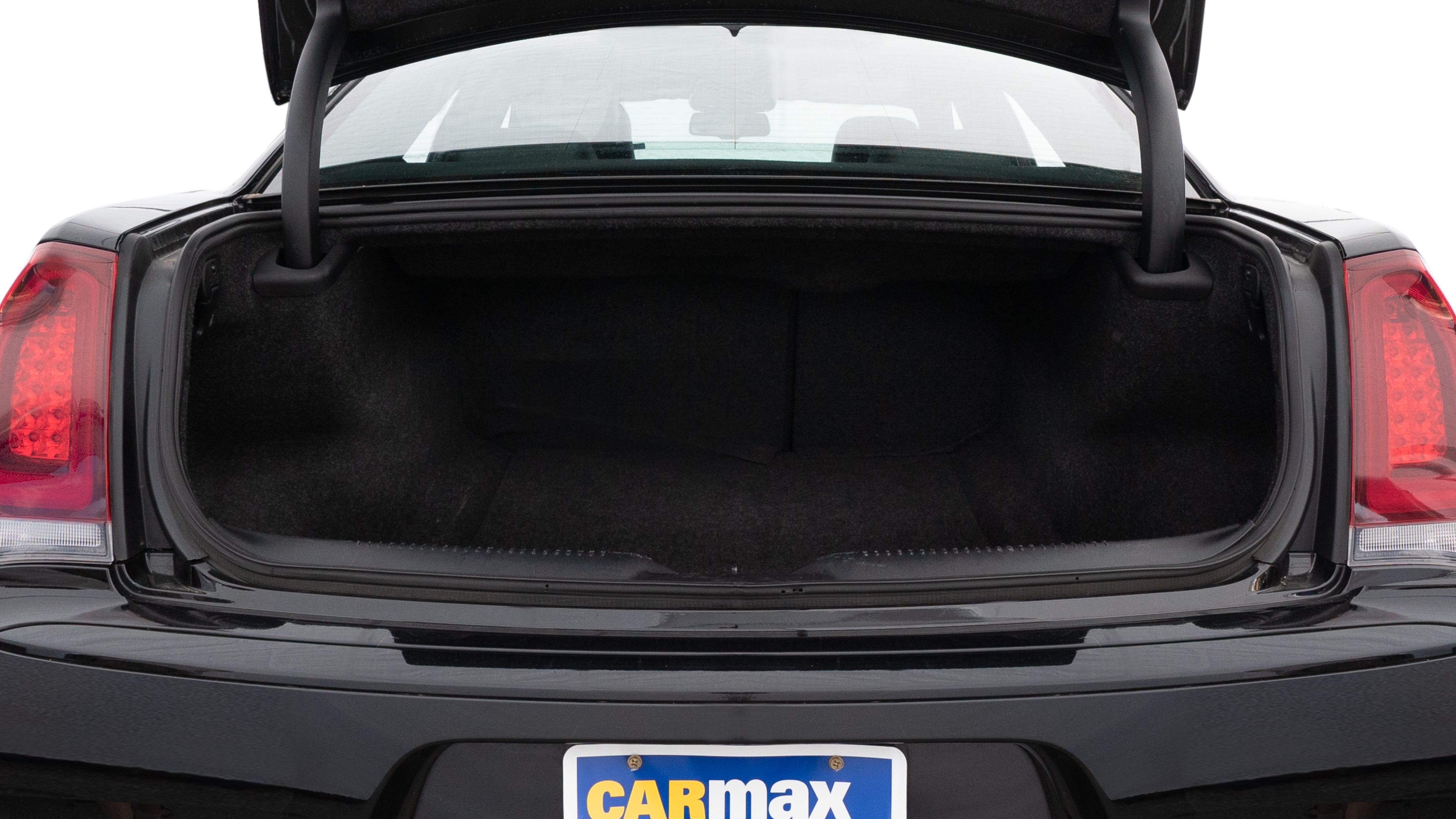 The trunk lid is open showing full view of the trunk. A baby stroller, three grocery carriers, two camping chairs in the carrying bag, and a set of golf clubs are placed inside.